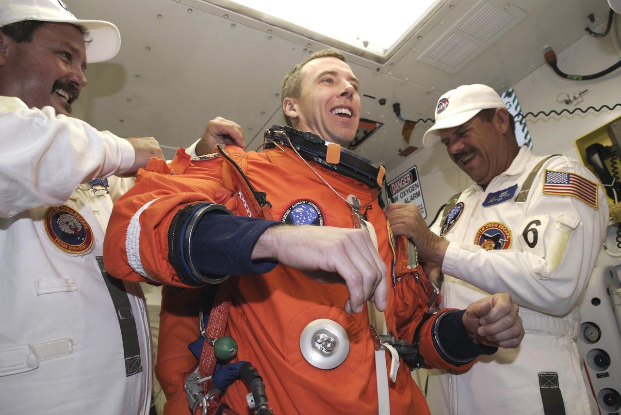 CAPE CANAVERAL, Fla. - STS-125 Mission Specialist Andrew Feustel is helped by suit technicians to don a harness over his launch and entry suit before entering space shuttle Atlantis for a simulated launch countdown. The countdown is the culmination of terminal countdown demonstration test, or TCDT, activities as preparation before launch. TCDT provides astronauts and ground crews with an opportunity to participate in various launch activities, including equipment familiarization, emergency training and the countdown. Atlantis’ STS-125 mission to service NASA’s Hubble Space Telescope is targeted for launch Oct. 14. Photo credit: NASA/Amanda Diller
