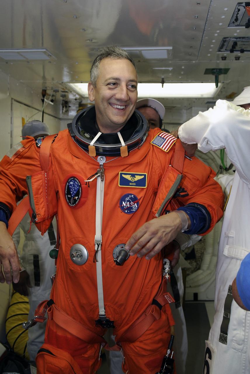 CAPE CANAVERAL, Fla. - STS-125 Mission Specialist Mike Massimino s helped by a suit technician to don a harness over his launch and entry suit before entering space shuttle Atlantis for a simulated launch countdown. The countdown is the culmination of terminal countdown demonstration test, or TCDT, activities as preparation before launch. TCDT provides astronauts and ground crews with an opportunity to participate in various launch activities, including equipment familiarization, emergency training and the countdown. Atlantis’ STS-125 mission to service NASA’s Hubble Space Telescope is targeted for launch Oct. 14. Photo credit: NASA/Amanda Diller