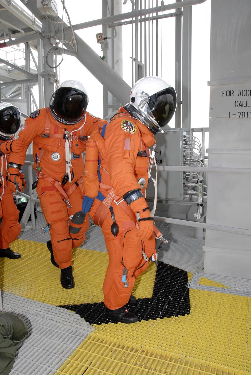 CAPE CANAVERAL, Fla. - After taking part in a simulated launch countdown aboard space shuttle Atlantis, the STS-125 crew members practice an emergency escape from the shuttle. They are heading for the slidewire baskets that will speed them away from Kennedy Space Center’s Launch Pad 39A. The countdown is the culmination of terminal countdown demonstration test, or TCDT, activities as preparation before launch. TCDT provides astronauts and ground crews with an opportunity to participate in various launch activities, including equipment familiarization, emergency training and the countdown. Atlantis’ STS-125 mission to service NASA’s Hubble Space Telescope is targeted for launch Oct. 14. Photo credit: NASA/Kim Shiflett