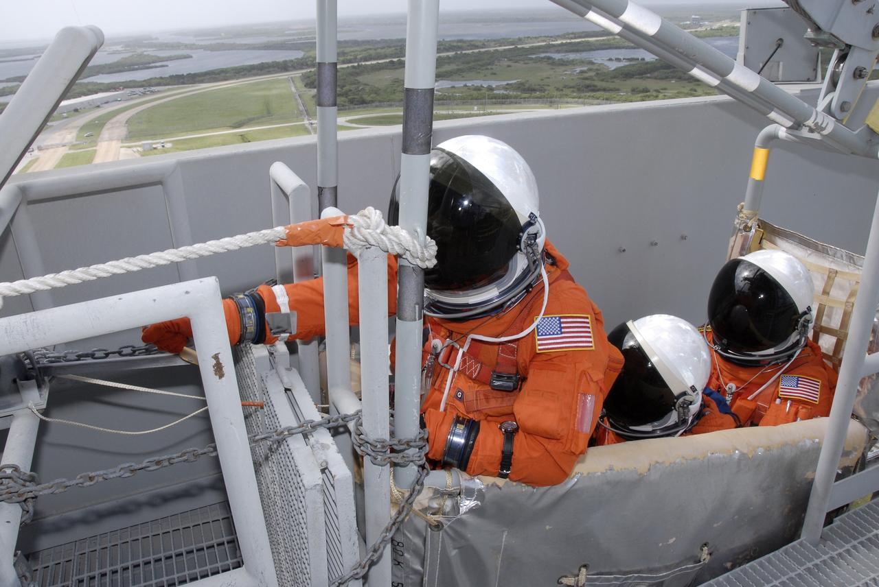 CAPE CANAVERAL, Fla. - After taking part in a simulated launch countdown aboard space shuttle Atlantis, the STS-125 crew members practice an emergency escape from the shuttle. Here they are ready to release the slidewire basket that will speed them away from Kennedy Space Center’s Launch Pad 39A. The countdown is the culmination of terminal countdown demonstration test, or TCDT, activities as preparation before launch. TCDT provides astronauts and ground crews with an opportunity to participate in various launch activities, including equipment familiarization, emergency training and the countdown. Atlantis’ STS-125 mission to service NASA’s Hubble Space Telescope is targeted for launch Oct. 14. Photo credit: NASA/Kim Shiflett