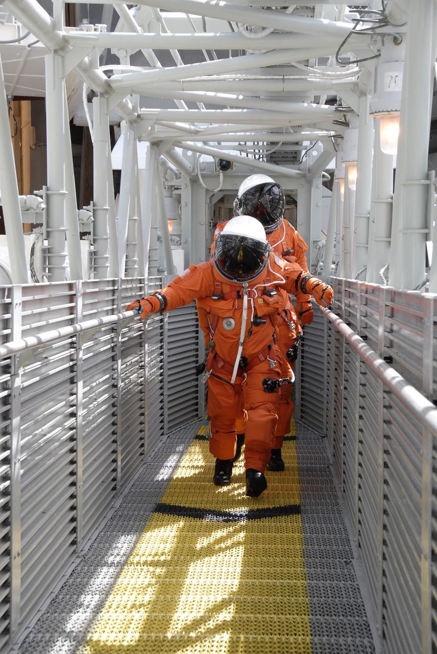 CAPE CANAVERAL, FIa. -- After taking part in a simulated launch countdown aboard space shuttle Atlantis, the STS-125 crew members practice an emergency escape from the shuttle. They are heading for the slidewire baskets that will speed them away from Kennedy Space Center’s Launch Pad 39A. The countdown is the culmination of terminal countdown demonstration test, or TCDT, activities as preparation before launch. TCDT provides astronauts and ground crews with an opportunity to participate in various launch activities, including equipment familiarization, emergency training and the countdown. Atlantis’ STS-125 mission to service NASA’s Hubble Space Telescope is targeted for launch Oct. 14. Photo credit: NASA/Kim Shiflett