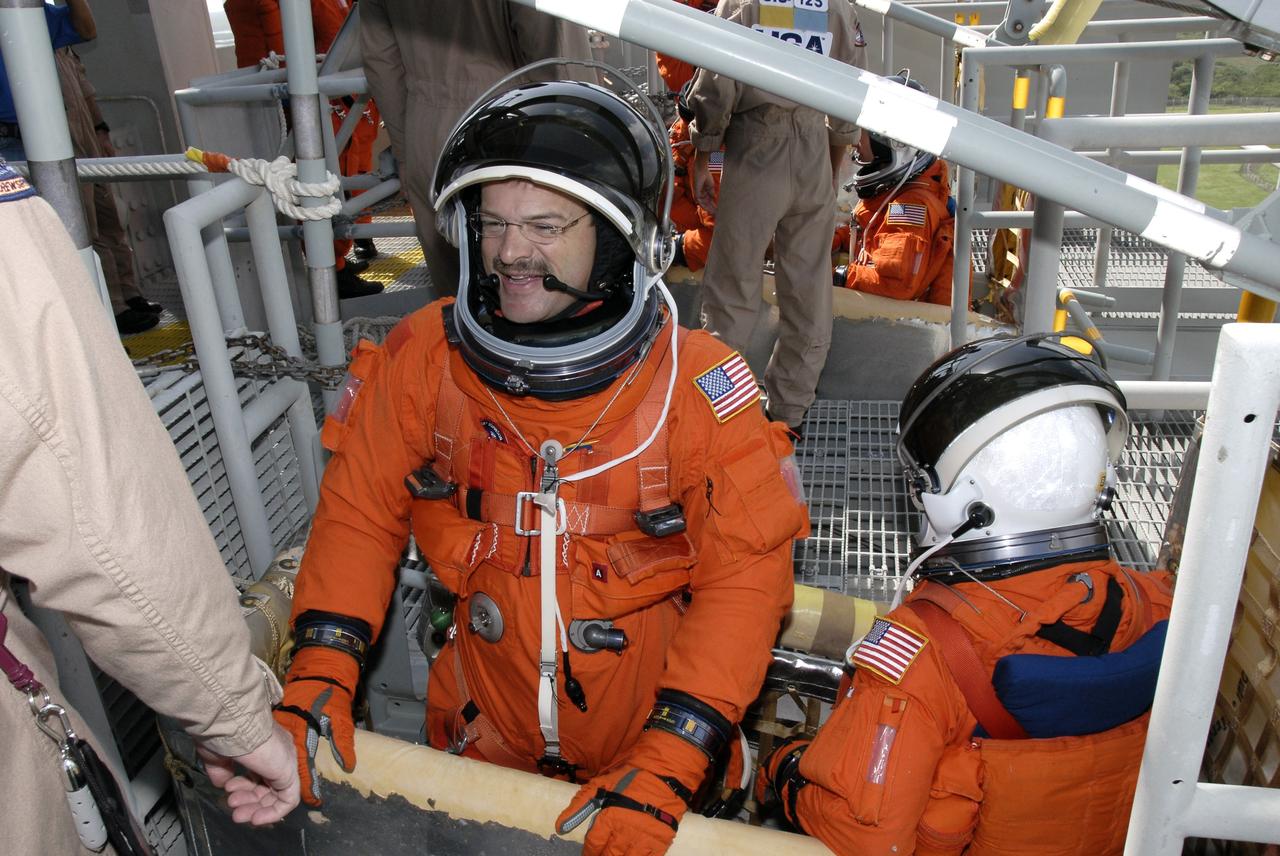 CAPE CANAVERAL, Fla. - After taking part in a simulated launch countdown aboard space shuttle Atlantis, the STS-125 crew members practice an emergency escape from the shuttle. Here Commander Scott Altman (left) and Pilot Gregory C. Johnson are in place in a slidewire basket on the fixed service structure that will speed them away from Kennedy Space Center’s Launch Pad 39A. The countdown is the culmination of terminal countdown demonstration test, or TCDT, activities as preparation before launch. TCDT provides astronauts and ground crews with an opportunity to participate in various launch activities, including equipment familiarization, emergency training and the countdown. Atlantis’ STS-125 mission to service NASA’s Hubble Space Telescope is targeted for launch Oct. 14. Photo credit: NASA/Kim Shiflett