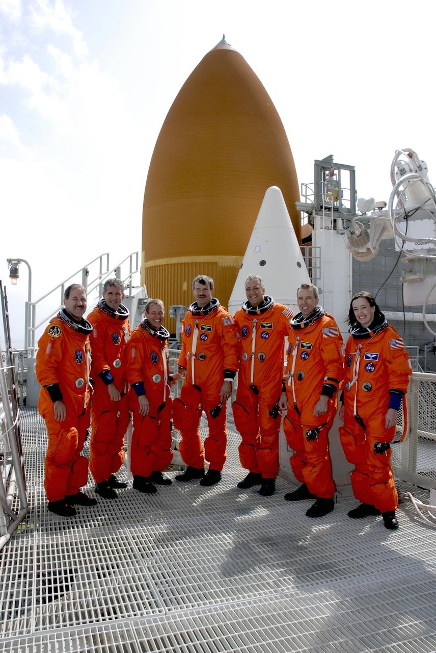 CAPE CANAVERAL, Fla. -  After taking part in a simulated launch countdown aboard space shuttle Atlantis and practicing emergency escape procedures, the STS-125 crew pauses for a photo on the 225-foot level of the fixed service structure at Launch Pad 39A at NASA's Kennedy Space Center in Florida.  From left are Mission Specialists John Grunsfeld and Michael Good, Pilot Gregory C. Johnson, Commander Scott Altman, and Mission Specialists Mike Massimino, Andrew Feustel and Megan McArthur.  Behind them are space shuttle Atlantis’ external fuel tank and one of the twin solid rocket boosters. The countdown is the culmination of terminal countdown demonstration test, or TCDT, activities as preparation before launch.  TCDT provides astronauts and ground crews with an opportunity to participate in various launch activities, including equipment familiarization, emergency training and the countdown.  Atlantis’ STS-125 mission to service NASA’s Hubble Space Telescope is targeted for launch Oct. 14. Photo credit: NASA/Kim Shiflett