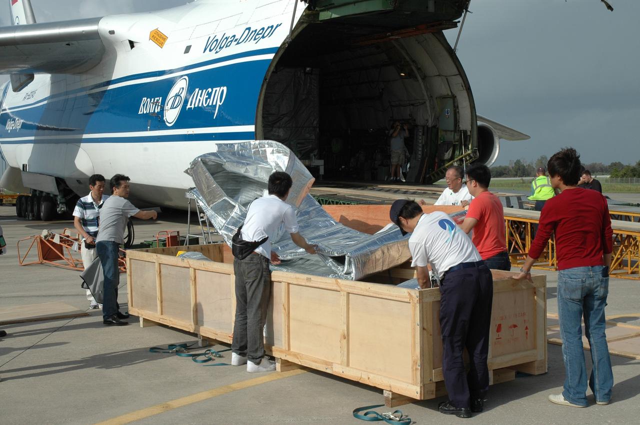 CAPE CANAVERAL, Fla. - On the Shuttle Landing Facility at NASA's Kennedy Space Center in Florida, workers remove material from a cargo box before offloading the primary cargo from the Russian Antonov AH-124-100 cargo airplane. The plane carries the final components of the Japan Aerospace Exploration Agency's Kibo laboratory for the International Space Station: the Kibo Exposed Facility, or EF, and the Experiment Logistics Module Exposed Section, or ELM-ES. The EF provides a multipurpose platform where science experiments can be deployed and operated in the exposed environment. The payloads attached to the EF can be exchanged or retrieved by Kibo's robotic arm, the JEM Remote Manipulator System. The ELM-ES will be attached to the end of the EF to provide payload storage space and can carry up to three payloads at launch. In addition, the ELM-ES provides a logistics function where it can be detached from the EF and returned to the ground aboard the space shuttle. The two JEM components will be carried aboard space shuttle Endeavour on the STS-127 mission targeted for launch in May 2009. Photo credit: NASA/Jim Grossmann