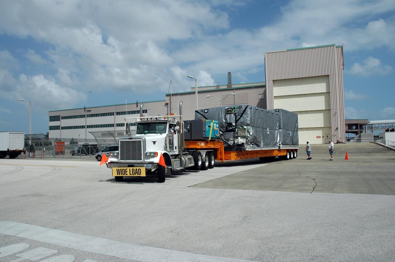 CAPE CANAVERAL, Fla. - A flatbed trailer carrying the final components of the Japan Aerospace Exploration Agency's Kibo laboratory for the International Space Station delivers them to the Space Station Processing Facility at NASA's Kennedy Space Center in Florida. The components are the Kibo Exposed Facility, or EF, and the Experiment Logistics Module Exposed Section, or ELM-ES. The EF provides a multipurpose platform where science experiments can be deployed and operated in the exposed environment. The payloads attached to the EF can be exchanged or retrieved by Kibo's robotic arm, the JEM Remote Manipulator System. The ELM-ES will be attached to the end of the EF to provide payload storage space and can carry up to three payloads at launch. In addition, the ELM-ES provides a logistics function where it can be detached from the EF and returned to the ground aboard the space shuttle. The two JEM components will be carried aboard space shuttle Endeavour on the STS-127 mission targeted for launch in May 2009. Photo credit: NASA/Dimitri Gerondidakis