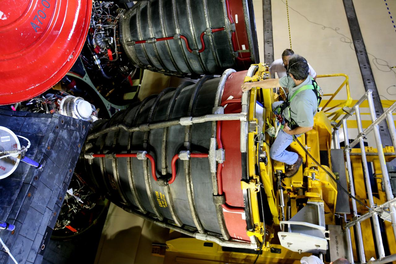 CAPE CANAVERAL, Fla. - In Orbiter Processing Facility bay 3 at NASA's Kennedy Space Center in Florida, workers make adjustments to install space shuttle main engine No. 3 in space shuttle Discovery. Each engine is 14 feet long, weighs about 6,700 pounds, and is 7.5 feet in diameter at the end of the nozzle. Discovery is being processed for its next mission, STS-119, targeted for launch on Feb. 12, 2009. Discovery and its crew will deliver integrated truss structure 6 (S6) and solar arrays to the International Space Station. Photo credit: NASA/Dimitri Gerondidakis