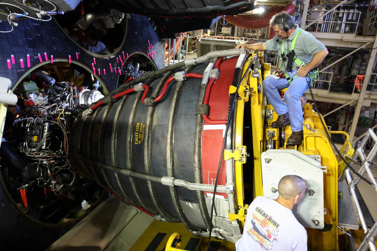 CAPE CANAVERAL, Fla. - In Orbiter Processing Facility bay 3 at NASA's Kennedy Space Center in Florida, workers make adjustments to install space shuttle main engine No. 3 in space shuttle Discovery. Each engine is 14 feet long, weighs about 6,700 pounds, and is 7.5 feet in diameter at the end of the nozzle. Discovery is being processed for its next mission, STS-119, targeted for launch on Feb. 12, 2009. Discovery and its crew will deliver integrated truss structure 6 (S6) and solar arrays to the International Space Station. Photo credit: NASA/Dimitri Gerondidakis