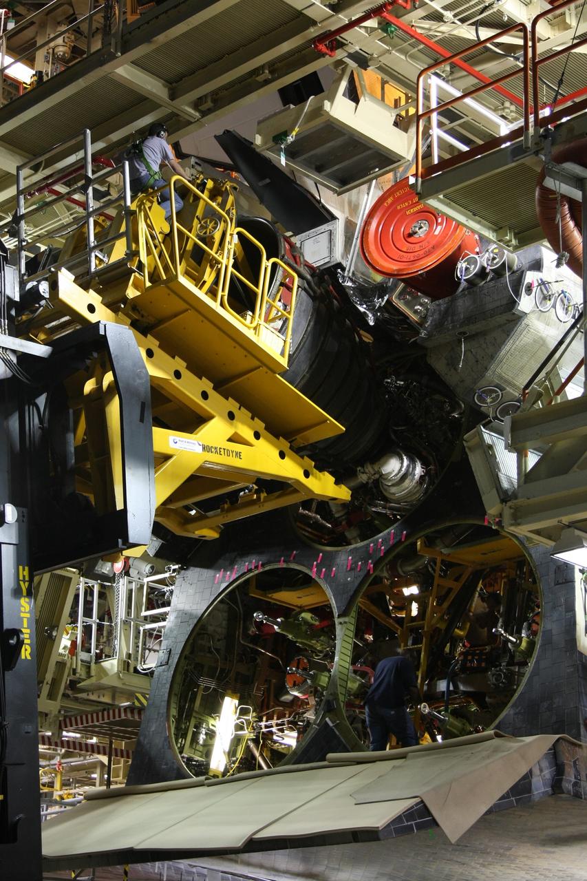 CAPE CANAVERAL, Fla. - Using a Hyster forklift, workers maneuver space shuttle main engine No. 1 (top) into place in space shuttle Discovery in Orbiter Processing Facility bay 3 at NASA's Kennedy Space Center in Florida. Each engine is 14 feet long, weighs about 6,700 pounds, and is 7.5 feet in diameter at the end of the nozzle. Discovery is being processed for its next mission, STS-119, targeted for launch on Feb. 12, 2009. Discovery and its crew will deliver integrated truss structure 6 (S6) and solar arrays to the International Space Station. Photo credit: NASA/Dimitri Gerondidakis