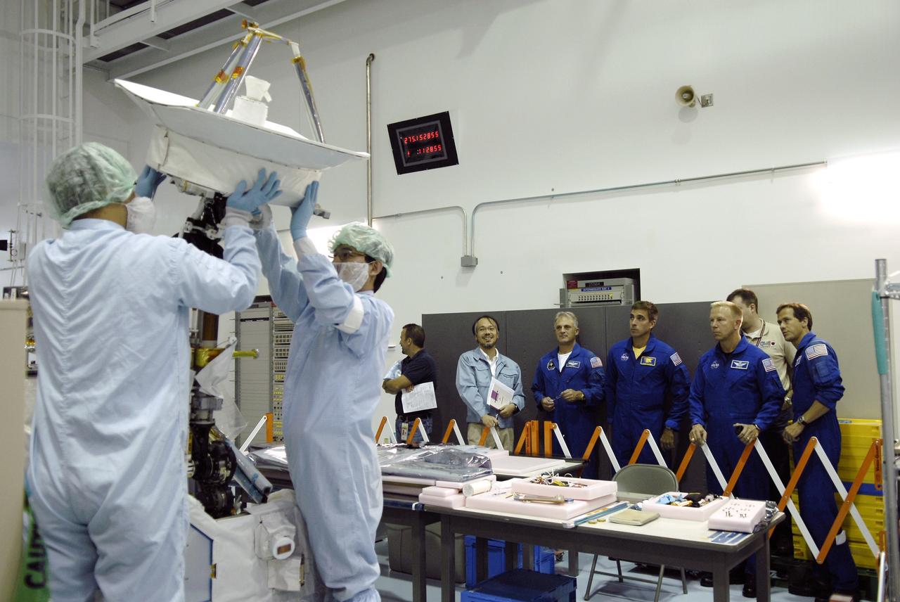 CAPE CANAVERAL, Fla. - In the Space Station Processing Facility at NASA's Kennedy Space Center in Florida, STS-127 crew members watch as Japanese Aerospace Exploration Agency, or JAXA, technicians maneuver the antenna in the Inter Orbit Communication System Extended Facility, or ICS-EF. Standing at right are Mission Specialists Dave Wolf, Christopher Cassidy, Tim Kopra and Tom Marshburn. Equipment familiarization is part of a Crew Equipment Interface Test. The antenna and a pointing mechanism will be used to communicate with JAXA’s Data Relay Test Satellite, or DRTS. The ICS-EF will be launched, along with the Extended Facility and Experiment Logistics Module-Exposed Section, to the International Space Station aboard the space shuttle Endeavour on the STS-127 mission targeted for launch on May 15, 2009. Photo credit: NASA/Kim Shiflett