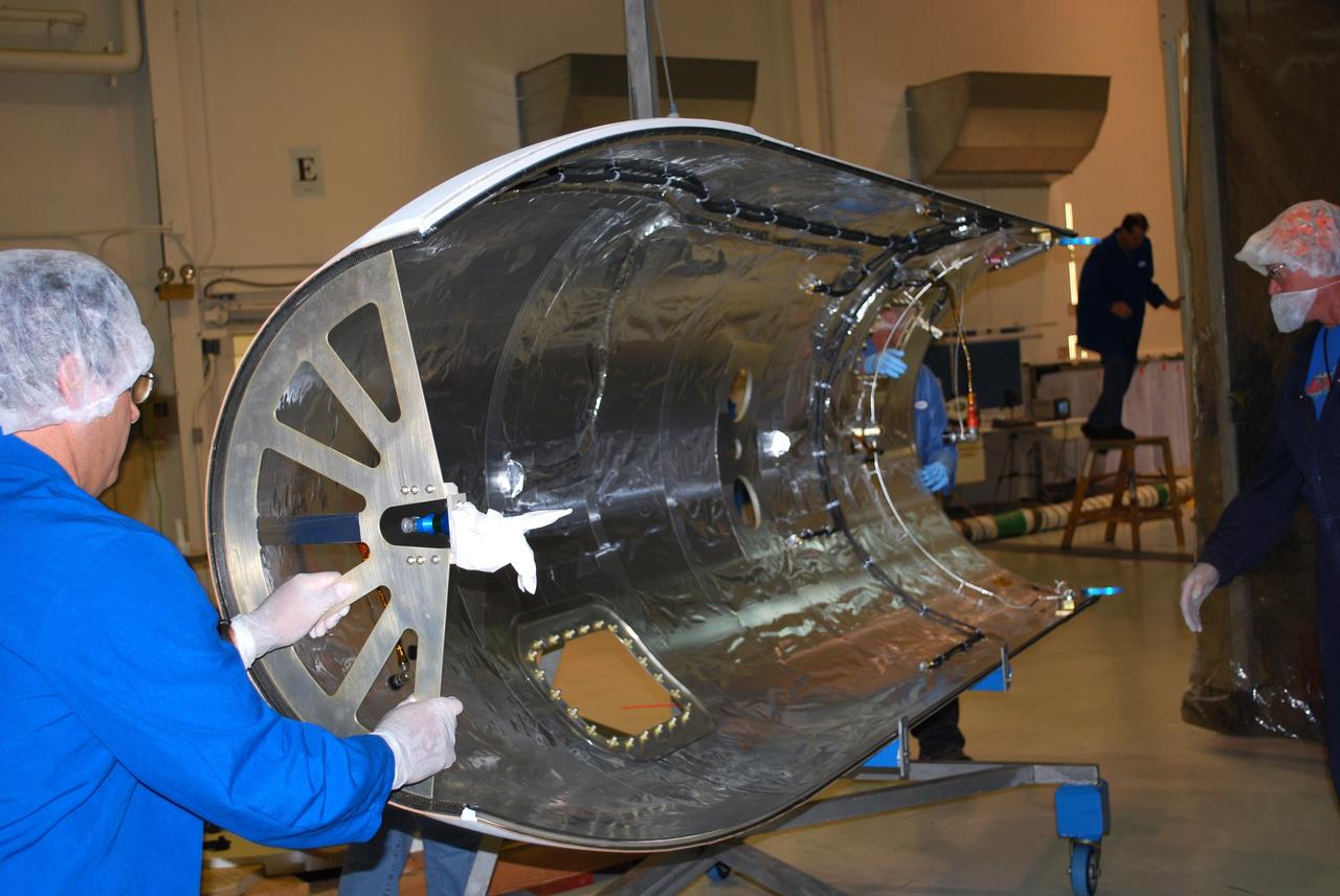 VANDENBERG AIR FORCE BASE , Calif. –   On Vandenberg Air Force Base in California, one half of a fairing is being moved to a protected clean room tent where it will be installed around NASA’s Interstellar Boundary Explorer, or IBEX, spacecraft. The fairing is a molded structure that fits flush with the outside surface of the rocket and forms an aerodynamically smooth nose cone, protecting the spacecraft during launch and ascent. The IBEX satellite will make the first map of the boundary between the Solar System and interstellar space. IBEX is targeted for launch from the Kwajalein Atoll, a part of the Marshall Islands in the Pacific Ocean, on Oct.  19.  IBEX will be launched aboard a Pegasus rocket dropped from under the wing of an L-1011 aircraft flying over the Pacific Ocean. The Pegasus will carry the spacecraft approximately 130 miles above Earth and place it in orbit.  Photo credit: NASA/Randy Beaudoin, VAFB