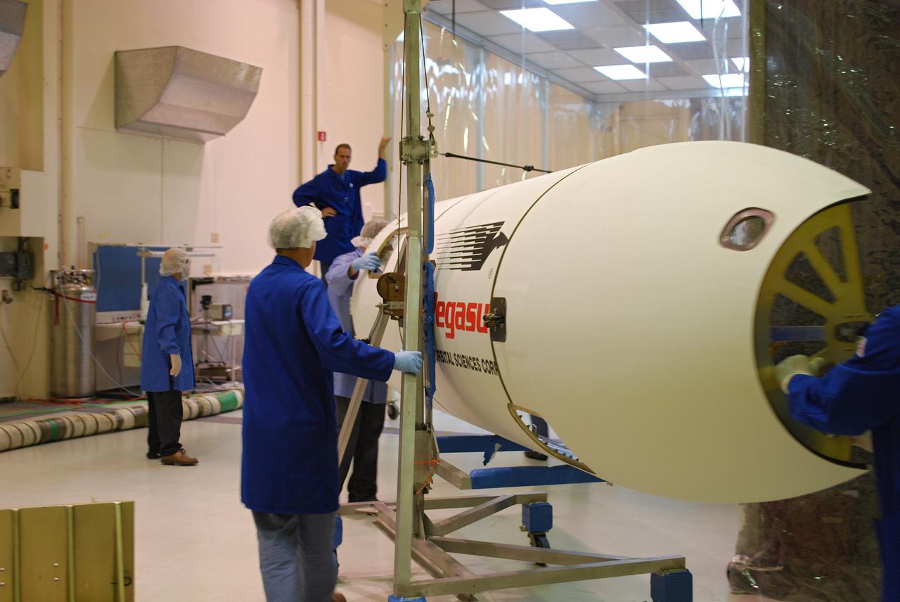 Vandenberg Air Force Base, Calif. –   On Vandenberg Air Force Base in California, one half of a fairing is moved into a protected clean room tent where it will be installed around NASA’s Interstellar Boundary Explorer, or IBEX, spacecraft. The fairing is a molded structure that fits flush with the outside surface of the rocket and forms an aerodynamically smooth nose cone, protecting the spacecraft during launch and ascent. The IBEX satellite will make the first map of the boundary between the Solar System and interstellar space. IBEX is targeted for launch from the Kwajalein Atoll, a part of the Marshall Islands in the Pacific Ocean, on Oct.  19.  IBEX will be launched aboard a Pegasus rocket dropped from under the wing of an L-1011 aircraft flying over the Pacific Ocean. The Pegasus will carry the spacecraft approximately 130 miles above Earth and place it in orbit.  Photo credit: NASA/Randy Beaudoin, VAFB