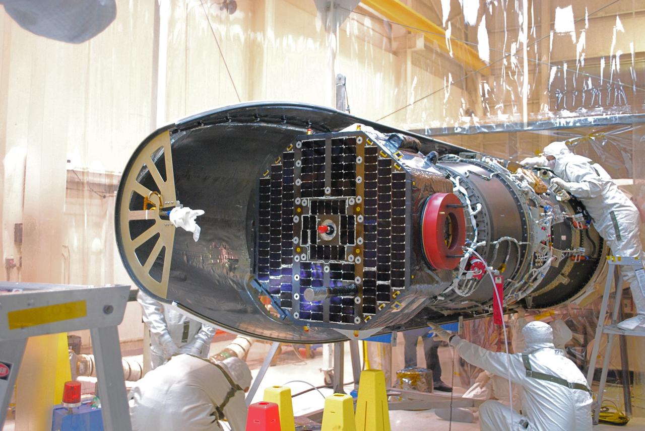 VANDENBERG AIR FORCE BASE, Calif. –   Inside a protected clean room tent on Vandenberg Air Force Base in California, workers install the fairing around NASA’s Interstellar Boundary Explorer, or IBEX, spacecraft. The fairing is a molded structure that fits flush with the outside surface of the rocket and forms an aerodynamically smooth nose cone, protecting the spacecraft during launch and ascent. The IBEX satellite will make the first map of the boundary between the Solar System and interstellar space. IBEX is targeted for launch from the Kwajalein Atoll, a part of the Marshall Islands in the Pacific Ocean, on Oct.  19.  IBEX will be launched aboard a Pegasus rocket dropped from under the wing of an L-1011 aircraft flying over the Pacific Ocean. The Pegasus will carry the spacecraft approximately 130 miles above Earth and place it in orbit.  Photo credit: NASA/Randy Beaudoin, VAFB