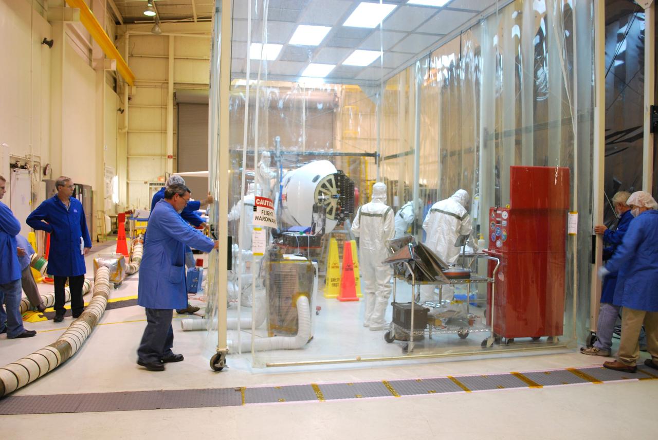 VANDENBERG AIR FORCE BASE, Calif. –   Inside a protected clean room tent on Vandenberg Air Force Base in California, workers install the fairing around NASA’s Interstellar Boundary Explorer, or IBEX, spacecraft.  The fairing is a molded structure that fits flush with the outside surface of the rocket and forms an aerodynamically smooth nose cone, protecting the spacecraft during launch and ascent. The IBEX satellite will make the first map of the boundary between the Solar System and interstellar space. IBEX is targeted for launch from the Kwajalein Atoll, a part of the Marshall Islands in the Pacific Ocean, on Oct.  19.  IBEX will be launched aboard a Pegasus rocket dropped from under the wing of an L-1011 aircraft flying over the Pacific Ocean. The Pegasus will carry the spacecraft approximately 130 miles above Earth and place it in orbit.  Photo credit: NASA/Randy Beaudoin, VAFB