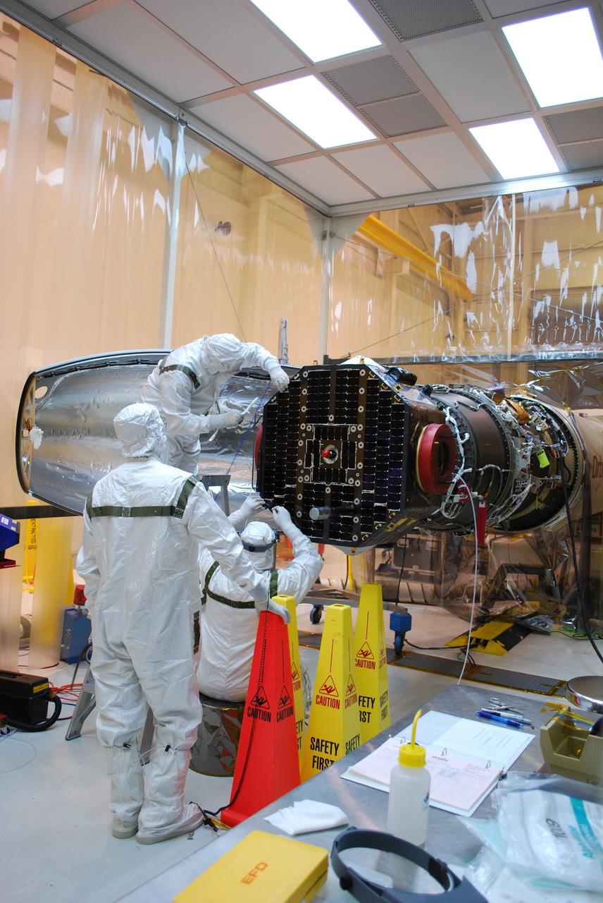 VANDENBERG AIR FORCE BASE, Calif. –   Inside a protected clean room tent on Vandenberg Air Force Base in California, workers make adjustments before installing the fairing around NASA’s Interstellar Boundary Explorer, or IBEX, spacecraft. The fairing is a molded structure that fits flush with the outside surface of the rocket and forms an aerodynamically smooth nose cone, protecting the spacecraft during launch and ascent. The IBEX satellite will make the first map of the boundary between the Solar System and interstellar space. IBEX is targeted for launch from the Kwajalein Atoll, a part of the Marshall Islands in the Pacific Ocean, on Oct.  19.  IBEX will be launched aboard a Pegasus rocket dropped from under the wing of an L-1011 aircraft flying over the Pacific Ocean. The Pegasus will carry the spacecraft approximately 130 miles above Earth and place it in orbit.  Photo credit: NASA/Randy Beaudoin, VAFB