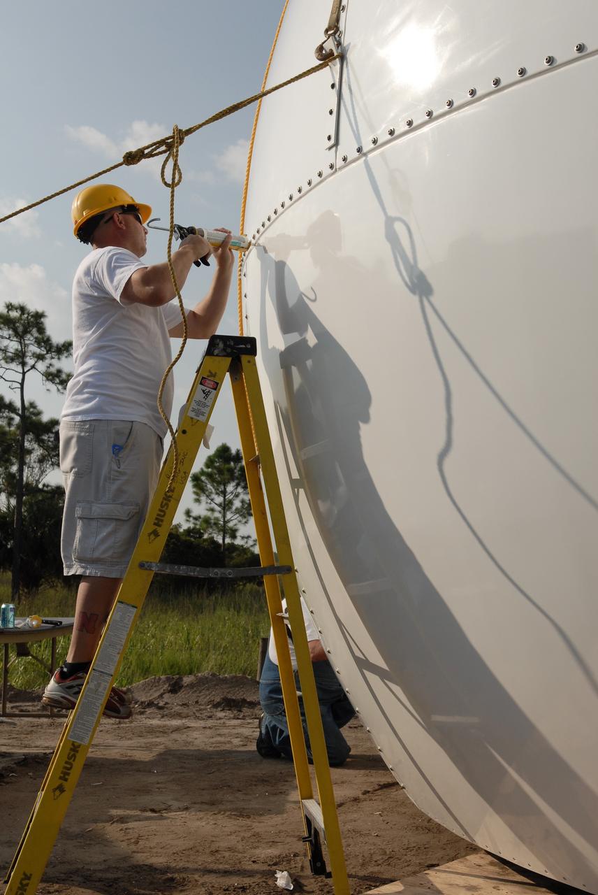 CAPE CANAVERAL, Fla. -   A worker seals an area of the radar dome, or radome, under construction on the Doppler weather radar facility for the 45th Weather Squadron being built in an area near S.R. 520 in Orange County, Florida. The new site will replace one at Patrick Air Force Base and will be used by NASA's Kennedy Space Center, the 45th Space Wing and their customers. The site will be able to monitor weather conditions directly above the launch pads at Kennedy. The weather radar is essential in issuing lightning and other severe weather warnings and vital in evaluating lightning launch commit criteria.  The new radar, replacing what was installed 25 years ago at Patrick Air Force Base, includes Doppler capability to detect winds and identify the type, size and number of precipitation particles.  The site is ideally distant from the launch pads and has unobstructed views of Cape Canaveral Air Force Station and Kennedy. The radar will be used by forecasters at the USAF 45th Weather Squadron. Photo credit: NASA/Troy Cryder