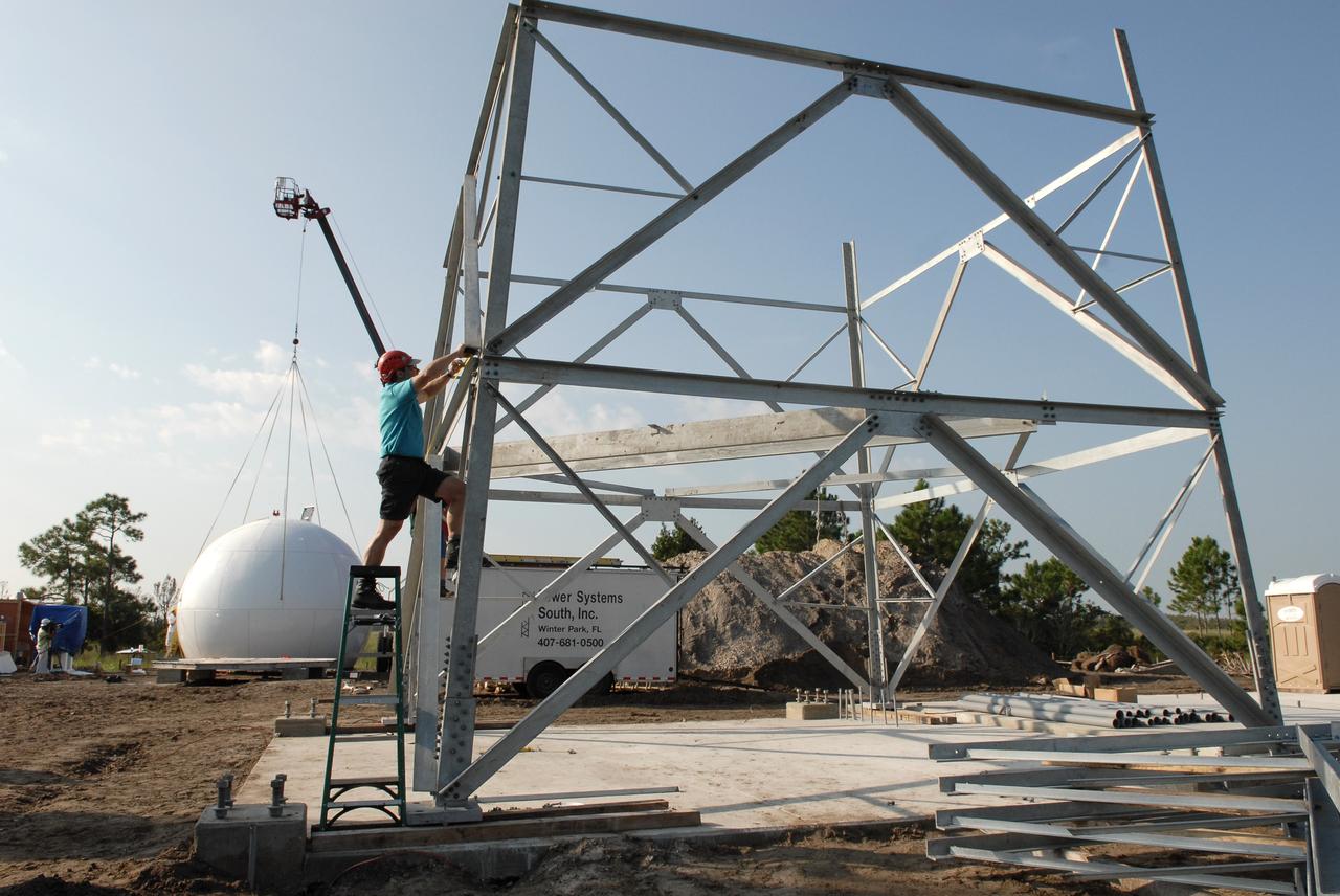 CAPE CANAVERAL, Fla. - Construction continues on the Doppler weather radar facility for the 45th Weather Squadron being built in an area near S.R. 520 in Orange County, Florida. In the background, left, is the radar dome, or radome, being prepared to lift. In the foreground is the tower being put together for the radome. The new site will replace one at Patrick Air Force Base and will be used by NASA's Kennedy Space Center, the 45th Space Wing and their customers. The site will be able to monitor weather conditions directly above the launch pads at Kennedy. The weather radar is essential in issuing lightning and other severe weather warnings and vital in evaluating lightning launch commit criteria.  The new radar, replacing what was installed 25 years ago at Patrick Air Force Base, includes Doppler capability to detect winds and identify the type, size and number of precipitation particles.  The site is ideally distant from the launch pads and has unobstructed views of Cape Canaveral Air Force Station and Kennedy. The radar will be used by forecasters at the USAF 45th Weather Squadron. Photo credit: NASA/Troy Cryder
