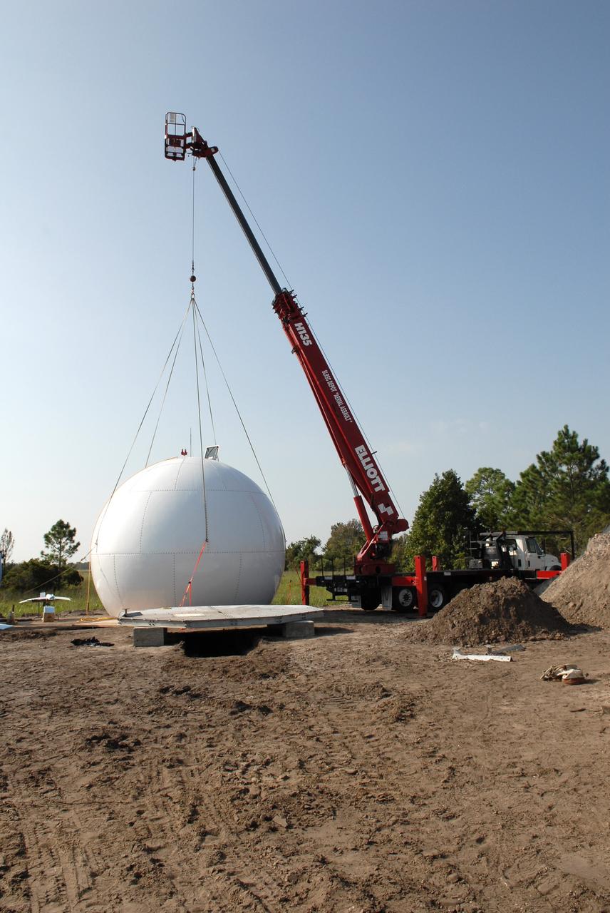 CAPE CANAVERAL, Fla. -In an area near S.R. 520 in Orange County, Florida, a crane begins lifting a radar dome, or radome, which is part of a new Doppler weather radar facility for the 45th Weather Squadron.  The new site replaces one at Patrick Air Force Base.  It will be used by NASA's Kennedy Space Center, the 45th Space Wing and their customers. The site will be able to monitor weather conditions directly above the launch pads at Kennedy. The weather radar is essential in issuing lightning and other severe weather warnings and vital in evaluating lightning launch commit criteria.  The new radar, replacing what was installed 25 years ago at Patrick Air Force Base, includes Doppler capability to detect winds and identify the type, size and number of precipitation particles.  The site is ideally distant from the launch pads and has unobstructed views of Cape Canaveral Air Force Station and Kennedy. The radar will be used by forecasters at the USAF 45th Weather Squadron. Photo credit: NASA/Troy Cryder