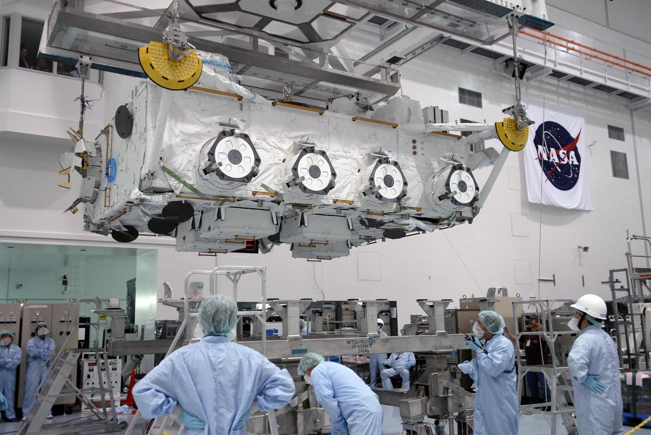 CAPE CANAVERAL, Fla. – In the Space Station Processing Facility at NASA's Kennedy Space Center in Florida, workers observe the movement of the Japan Aerospace Exploration Agency's Kibo Exposed Facility, or EF, as it is lowered toward a stand. The EF, along with the Experiment Logistics Module Exposed Section, will be carried aboard space shuttle Endeavour on the STS-127 mission to the International Space Station targeted for launch May 15, 2009. When it is installed on the Kibo laboratory,the EF will provide a multipurpose platform where science experiments can be deployed and operated in the exposed environment. The payloads attached to the EF can be exchanged or retrieved by Kibo's robotic arm, the JEM Remote Manipulator System. Photo credit: NASA/Kim Shiflett