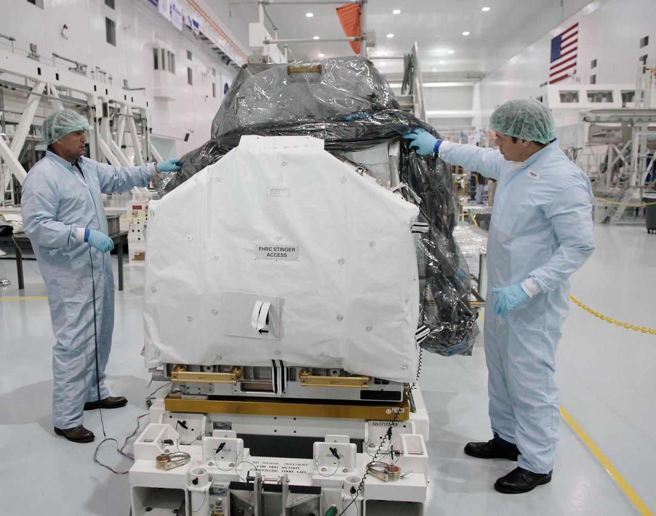 CAPE CANAVERAL, FIa. -- In the Space Station Processing Facility at NASA's Kennedy Space Center, astronauts Michael Foreman (left) and Robert Behnken (right) inspect the flexible hose rotary coupler that will fly on the STS-126 mission Nov. 14. Although not associated with the mission, Foreman and Behnken are crew members of the EVA branch who are providing their expertise for hardware going on the International Space Station. On the STS-126 mission, space shuttle Endeavour will deliver a Multi-Purpose Logistics Module to the International Space Station. Photo credit: NASA/Kim Shiflett