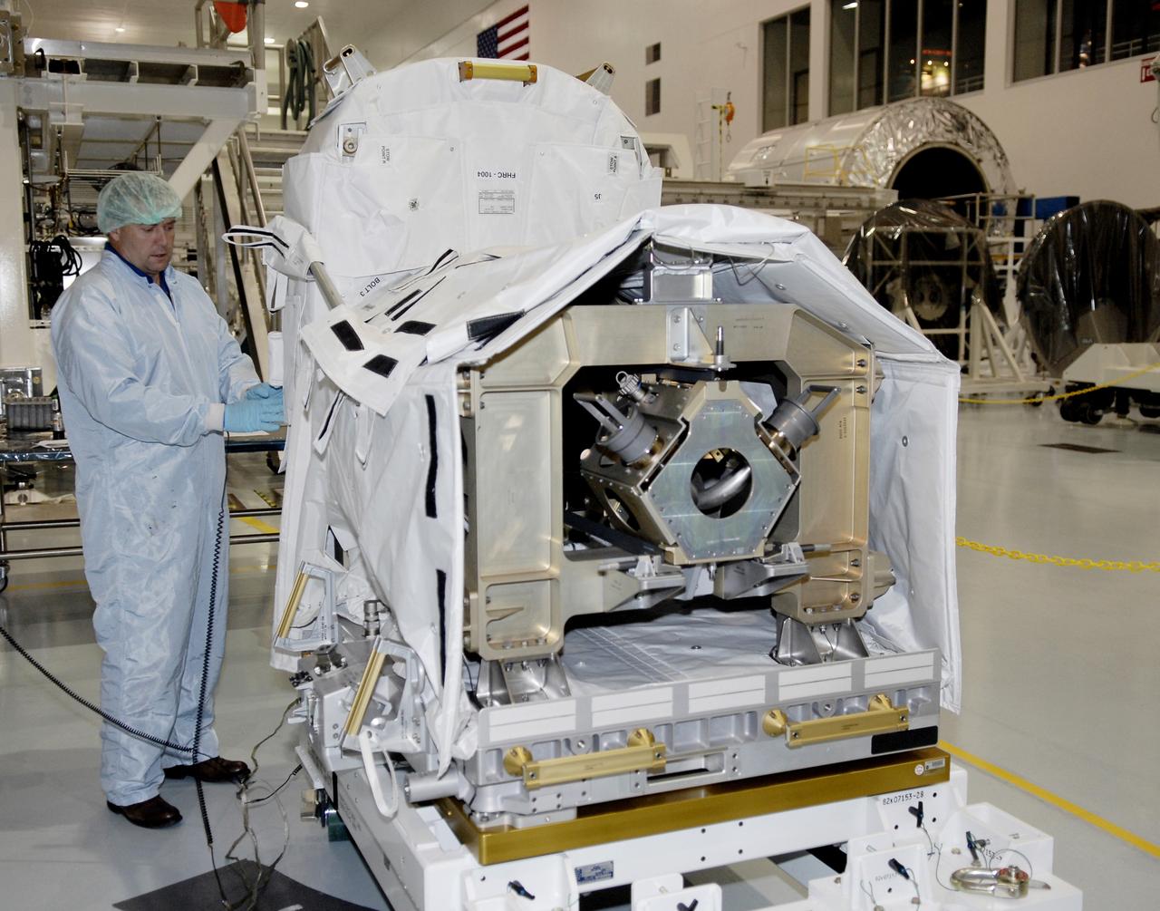 CAPE CANAVERAL, FIa. -- In the Space Station Processing Facility at NASA's Kennedy Space Center, astronaut Michael Foreman removes part of the cover on the flexible hose rotary coupler that will fly on the STS-126 mission Nov. 14. Although not associated with the mission, Foreman is an EVA branch crew member providing expertise for hardware going on the International Space Station. On the STS-126 mission, space shuttle Endeavour will deliver a Multi-Purpose Logistics Module to the International Space Station. Photo credit: NASA/Kim Shiflett