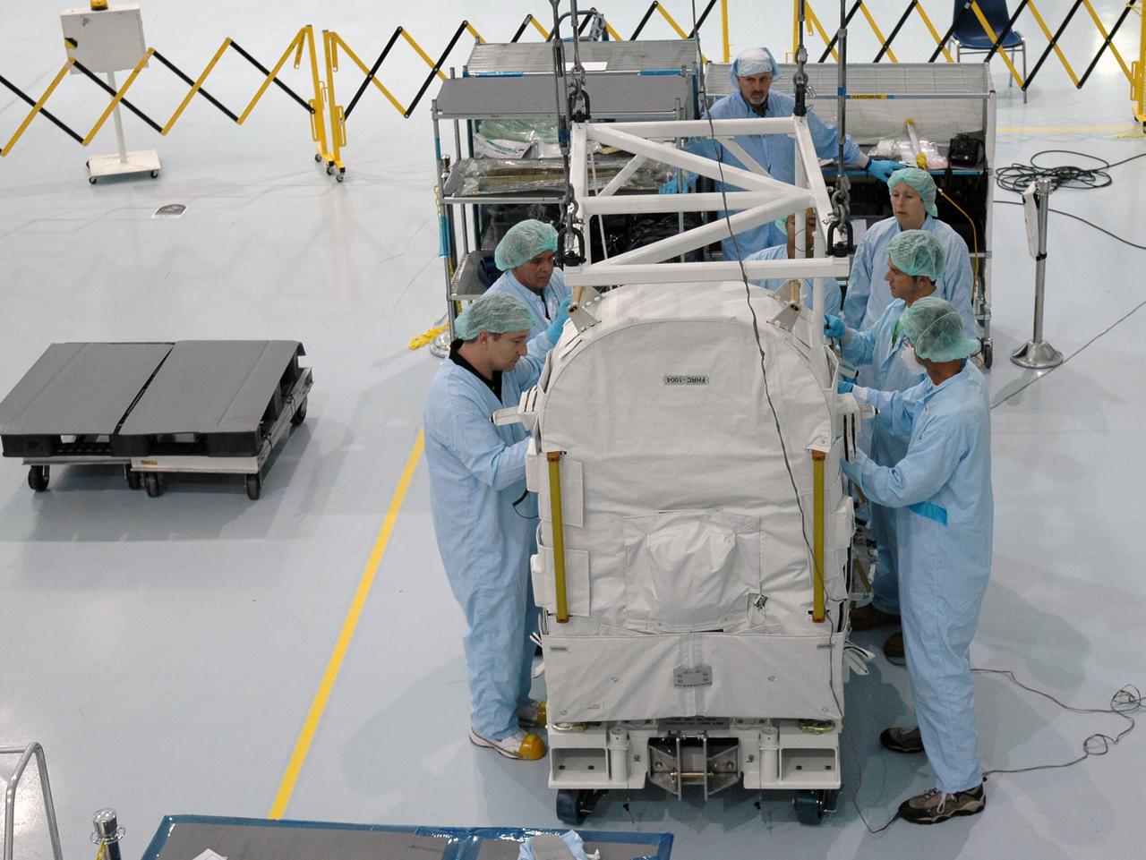 CAPE CANAVERAL, FIa. -- In the Space Station Processing Facility at NASA's Kennedy Space Center in Florida, workers attach an overhead crane to the flexible hose rotary coupler. After attachment, the crane will lift and move the coupler to the Lightweight Multi-Purpose Experiment Support Structure Carrier for installation. The carrier will be installed in space shuttle Endeavour for the STS-126 mission to the International Space Station. The 15-day flight will deliver equipment and supplies to the space station in preparation for expansion from a three- to six-person resident crew aboard the complex. The mission also will include four spacewalks to service the station’s Solar Alpha Rotary Joints. Photo credit: NASA/Jim Grossmann