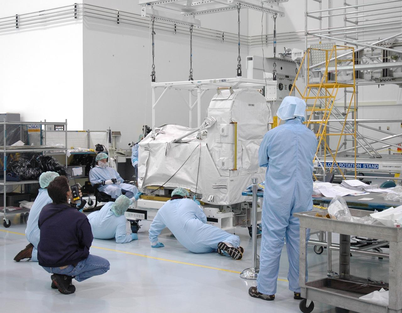 CAPE CANAVERAL, FIa. -- In the Space Station Processing Facility at NASA's Kennedy Space Center in Florida, workers keep close watch as an overhead crane lifts the flexible hose rotary coupler. The coupler will be moved to the Lightweight Multi-Purpose Experiment Support Structure Carrier for installation. The carrier will be installed in space shuttle Endeavour for the STS-126 mission to the International Space Station. The 15-day flight will deliver equipment and supplies to the space station in preparation for expansion from a three- to six-person resident crew aboard the complex. The mission also will include four spacewalks to service the station’s Solar Alpha Rotary Joints. Photo credit: NASA/Jim Grossmann