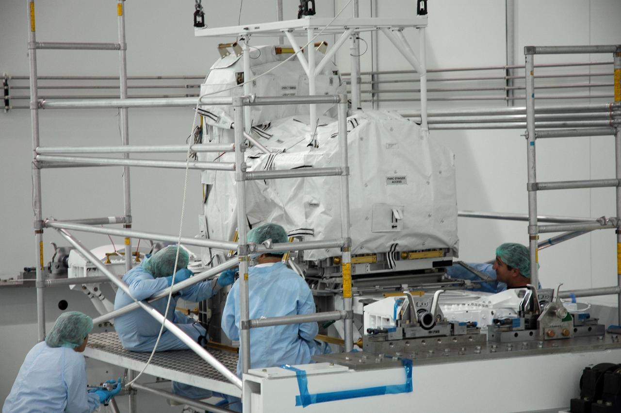 CAPE CANAVERAL, FIa. -- In the Space Station Processing Facility at NASA's Kennedy Space Center in Florida, workers keep close watch as the flexible hose rotary coupler is lowered onto the Lightweight Multi-Purpose Experiment Support Structure Carrier for installation. The carrier will be installed in space shuttle Endeavour for the STS-126 mission to the International Space Station. The 15-day flight will deliver equipment and supplies to the space station in preparation for expansion from a three- to six-person resident crew aboard the complex. The mission also will include four spacewalks to service the station’s Solar Alpha Rotary Joints. Photo credit: NASA/Jim Grossmann