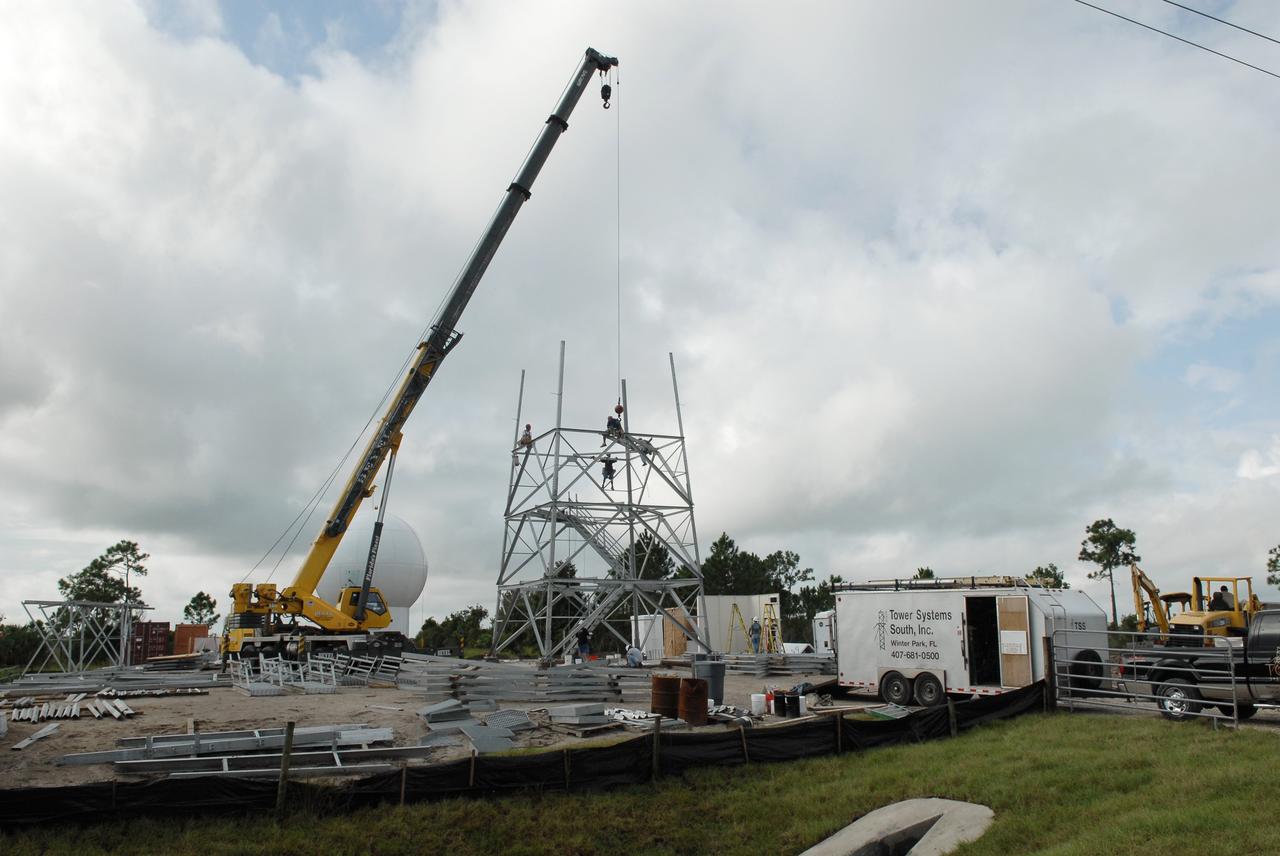 CAPE CANAVERAL, Fla. – In an area near S.R. 520 in Orange County, Florida, a crane is being used to lift steel beams for a new Doppler weather radar tower for the 45th Weather Squadron. In the background at left is the radome that will be on top of the tower. The new site replaces one at Patrick Air Force Base. It will be used by NASA's Kennedy Space Center, the 45th Space Wing and their customers. The site will be able to monitor weather conditions directly above and surrounding the launch pads at Kennedy.  The weather radar is essential in issuing lightning and other severe weather warnings and vital in evaluating lightning launch commit criteria.  The new radar, replacing what was installed 25 years ago at Patrick Air Force Base, includes Doppler capability to detect winds and identify the type, size and number of precipitation particles.  The site is ideally distant from the launch pads and has unobstructed views of Cape Canaveral Air Force Station and Kennedy. The radar will be used by forecasters at the USAF 45th Weather Squadron. Photo credit: NASA/Troy Cryder