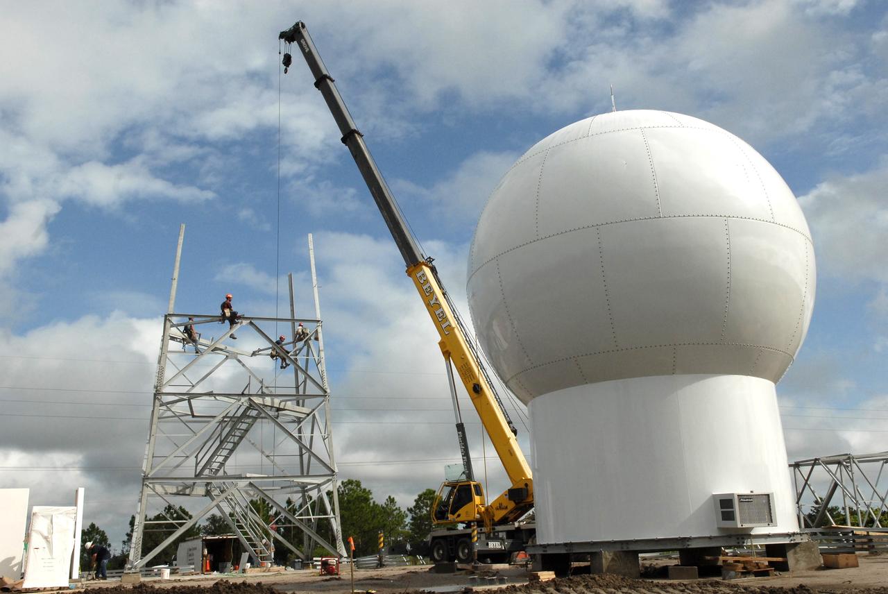 CAPE CANAVERAL, Fla. – In an area near S.R. 520 in Orange County, Florida, workers are constructing a steel tower for a Doppler weather radar facility for the 45th Weather Squadron. At right is the radome that will be on top of the tower.  The new site replaces one at Patrick Air Force Base. It will be used by NASA's Kennedy Space Center, the 45th Space Wing and their customers. The site will be able to monitor weather conditions directly above and surrounding the launch pads at Kennedy.  The weather radar is essential in issuing lightning and other severe weather warnings and vital in evaluating lightning launch commit criteria.  The new radar, replacing what was installed 25 years ago at Patrick Air Force Base, includes Doppler capability to detect winds and identify the type, size and number of precipitation particles.  The site is ideally distant from the launch pads and has unobstructed views of Cape Canaveral Air Force Station and Kennedy. The radar will be used by forecasters at the USAF 45th Weather Squadron. Photo credit: NASA/Troy Cryder