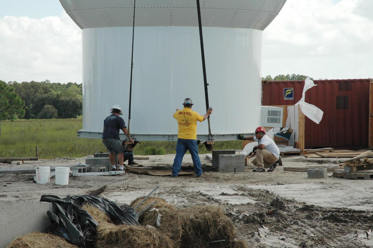CAPE CANAVERAL, Fla. – In an area near S.R. 520 in Orange County, Florida, workers help guide the cables on a crane lifting a radome onto concrete blocks.  The radome will be lifted onto a steel tower constructed for a Doppler weather radar for the 45th Weather Squadron.  The new site replaces one at Patrick Air Force Base and will be used by NASA's Kennedy Space Center, the U.S. Air Force's 45th Space Wing and their customers. The facility will be able to monitor weather conditions directly above and surrounding the launch pads at Kennedy.  The weather radar is essential in issuing lightning and other severe weather warnings and vital in evaluating lightning launch commit criteria.  Replacing what was installed 25 years ago at Patrick Air Force Base, the new radar includes Doppler capability to detect winds and identify the type, size and number of precipitation particles.  The site is ideally distant from the launch pads and has unobstructed views of Cape Canaveral Air Force Station and Kennedy. The radar will be used by forecasters at the USAF 45th Weather Squadron.  Photo credit: NASA/Jim Grossmann