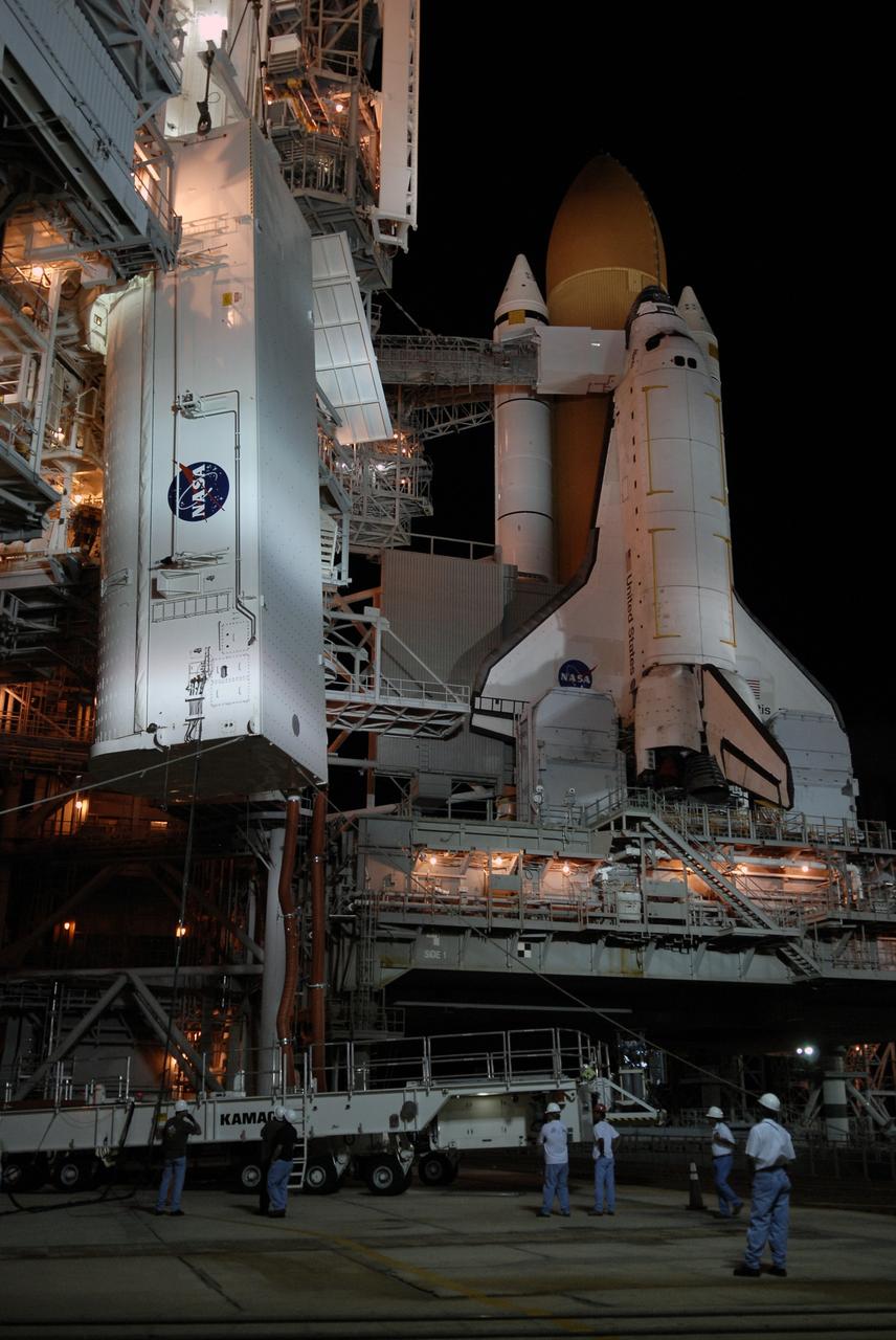 CAPE CANAVERAL, Fla. –  After transfer of space shuttle Atlantis’ HST payload on Launch Pad 39A on NASA's Kennedy Space Center in Florida, the payload canister, at left, is lowered toward the transporter below. The red umbilical lines keep the payload in an environmentally controlled environment.  The payload comprises four carriers holding various equipment for the mission.  The hardware will be transported back to Kennedy’s Payload Hazardous Servicing Facility where it will be stored until a new target launch date can be set for Atlantis’ STS-125 mission in 2009.  Atlantis’ October target launch date was delayed after a device on board Hubble used in the storage and transmission of science data to Earth shut down on Sept. 27.  Replacing the broken device will be added to Atlantis’ servicing mission to the telescope. Photo credit: NASA/Kim Shiflett