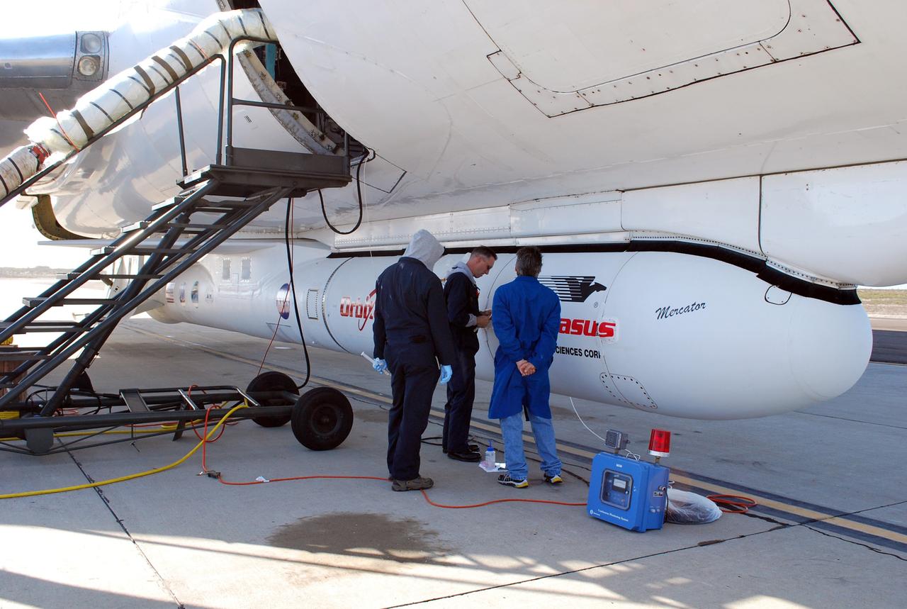 VANDENBERG AIR FORCE BASE, Calif. – On the ramp of Vandenberg Air Force Base in California, workers make final checks of the Pegasus XL rocket before departure for the Kwajalein Atoll, a part of the Marshall Islands in the Pacific Ocean.  Mated to NASA’s Interstellar Boundary Explorer, or IBEX, spacecraft, the Pegasus is attached under the wing of the aircraft for launch.  Departing from Kwajalein, the Pegasus rocket will be dropped from under the wing of the L-1011 over the Pacific Ocean to carry the spacecraft approximately 130 miles above Earth and place it in orbit.  Then, the spacecraft’s own engine will boost it to its final high-altitude orbit (about 200,000 miles high) — most of the way to the Moon. The IBEX satellite will make the first map of the boundary between the Solar System and interstellar space.  IBEX science will be led by the Southwest Research Institute of San Antonio, Texas.  IBEX is targeted for launch over the Pacific Oct. 19.   Photo credit: NASA/Randy Beaudoin, VAFB