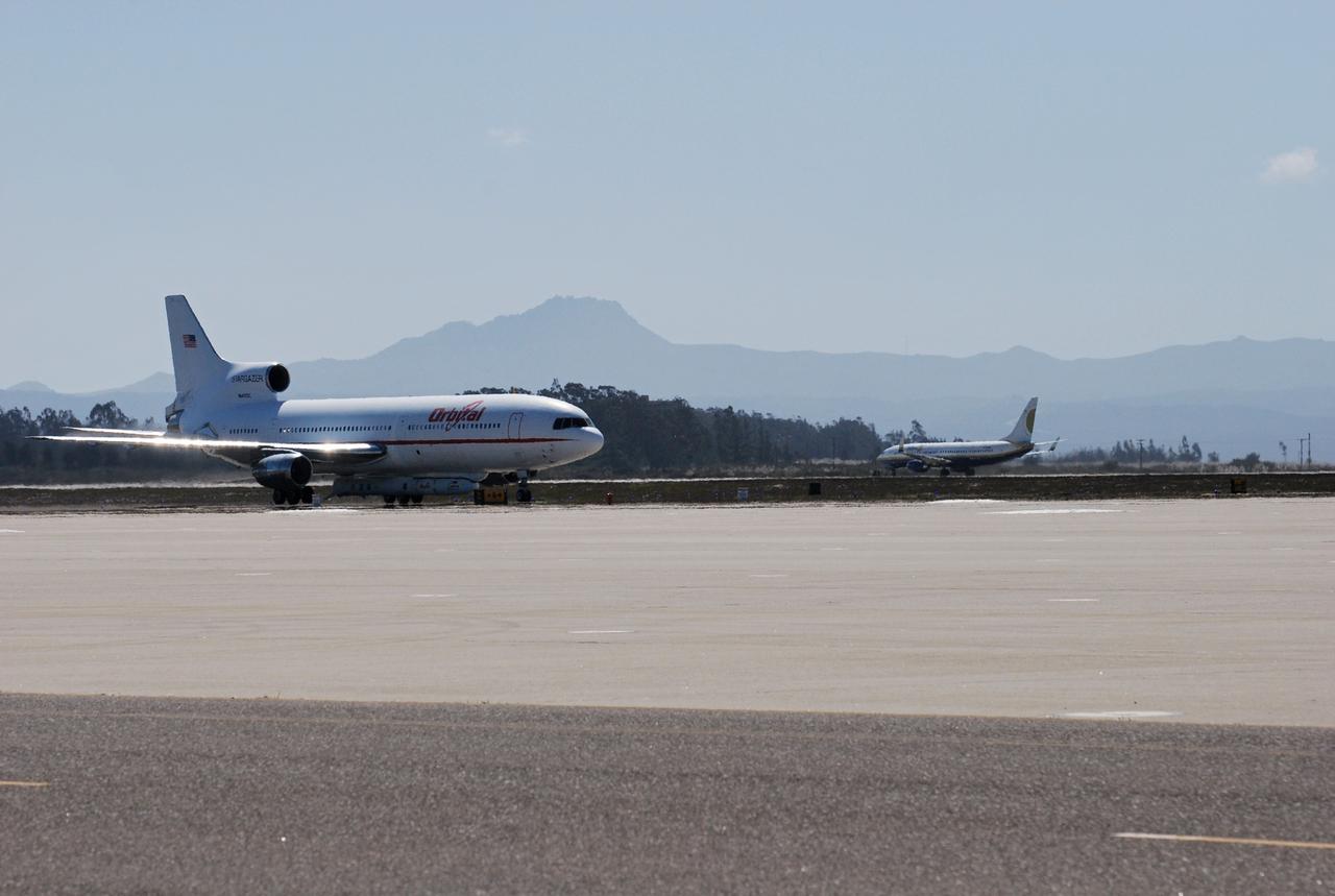 VANDENBERG AIR FORCE BASE, Calif. – On the ramp of Vandenberg Air Force Base in California, Orbital Sciences’ L-1011 aircraft awaits departure for the Kwajalein Atoll, a part of the Marshall Islands in the Pacific Ocean, with NASA’s Interstellar Boundary Explorer, or IBEX, spacecraft and Pegasus XL rocket. The Pegasus is attached under the wing of the aircraft for launch.  In the background at right is the Pathfinder aircraft that will accompany the L-1011 with a contingency crew and launch team members.  Departing from Kwajalein, the Pegasus rocket will be dropped from under the wing of the L-1011 over the Pacific Ocean to carry the spacecraft approximately 130 miles above Earth and place it in orbit.  Then, the spacecraft’s own engine will boost it to its final high-altitude orbit (about 200,000 miles high) — most of the way to the Moon. The IBEX satellite will make the first map of the boundary between the Solar System and interstellar space.  IBEX science will be led by the Southwest Research Institute of San Antonio, Texas.  IBEX is targeted for launch over the Pacific Oct. 19.   Photo credit: NASA/Randy Beaudoin, VAFB