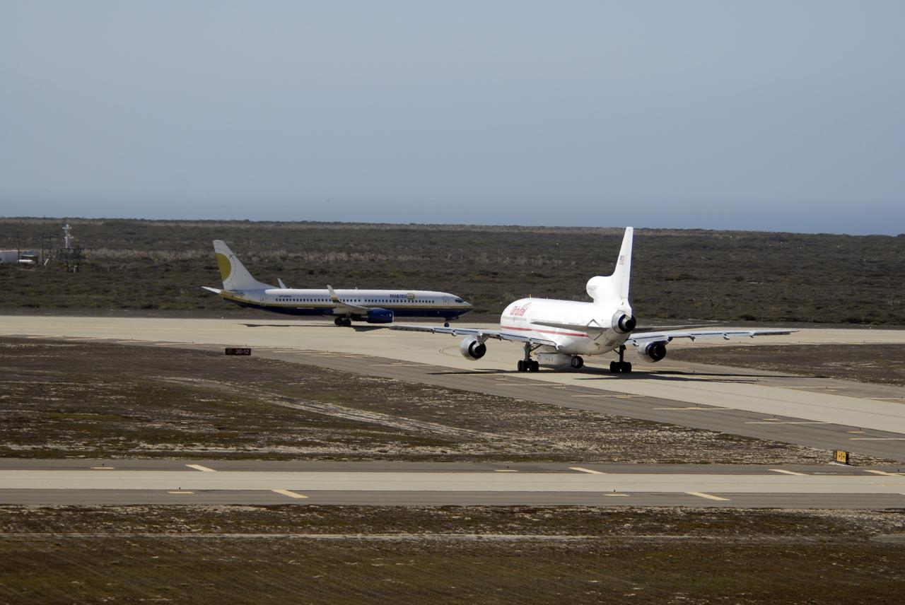 VANDENBERG AIR FORCE BASE, Calif. –  Orbital Sciences’ L-1011 aircraft (right) taxis on the runway for takeoff from Vandenberg Air Force Base in California to the Kwajalein Atoll, a part of the Marshall Islands in the Pacific Ocean.  Under its wing is NASA’s Interstellar Boundary Explorer, or IBEX, spacecraft and Pegasus XL rocket. At left is the Pathfinder aircraft that will accompany the L-1011, carrying the contingency crew and launch team members. Departing from Kwajalein, the Pegasus rocket will be dropped from under the wing of the L-1011 over the Pacific Ocean to carry the spacecraft approximately 130 miles above Earth and place it in orbit.  Then, the spacecraft’s own engine will boost it to its final high-altitude orbit (about 200,000 miles high) — most of the way to the Moon. The IBEX satellite will make the first map of the boundary between the Solar System and interstellar space.  IBEX science will be led by the Southwest Research Institute of San Antonio, Texas.  IBEX is targeted for launch over the Pacific Oct. 19.   Photo credit: NASA/VAFB
