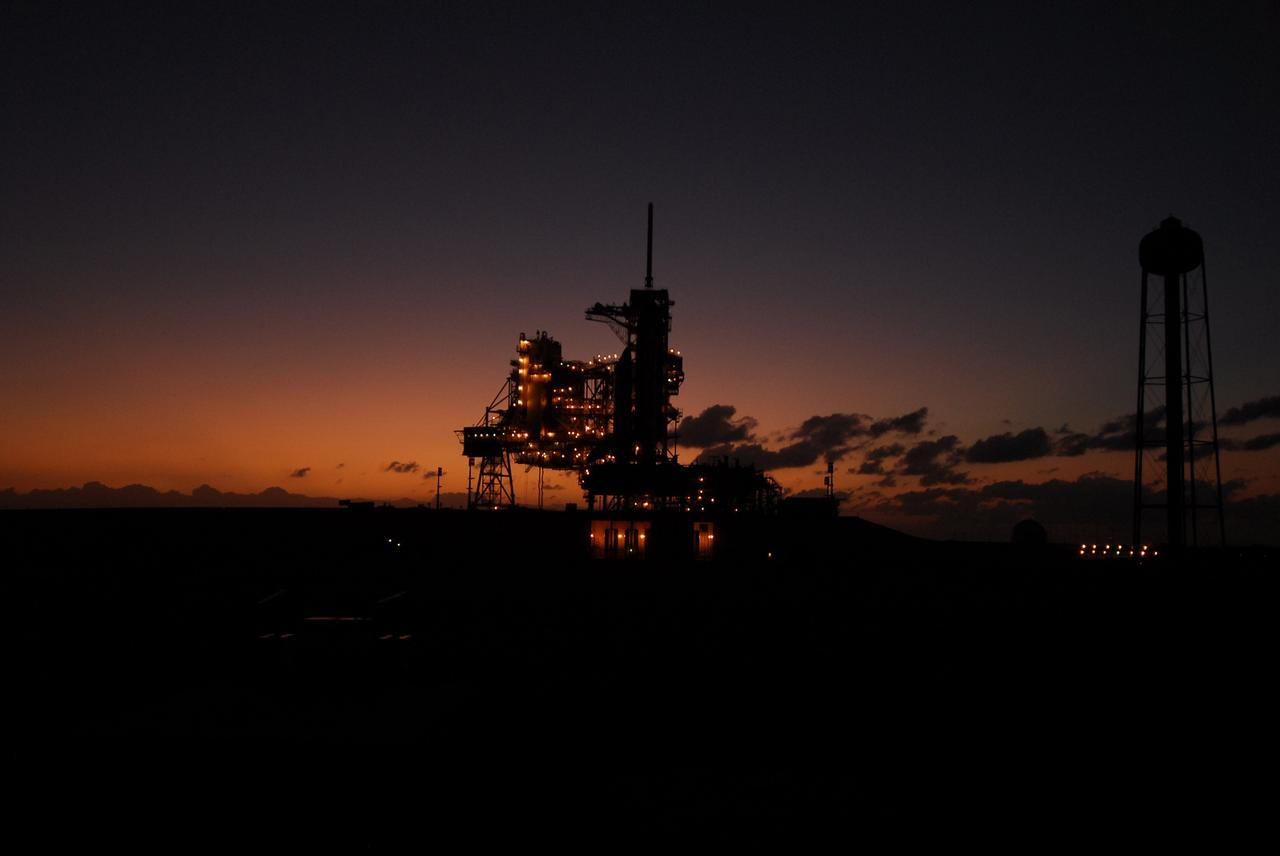 CAPE CANAVERAL, Fla. –  The deep-red sunset sky puts Launch pad 39A in silhouette.  Space shuttle Atlantis is on the pad. Atlantis’ October target launch date for the STS-125 Hubble Space Telescope servicing mission was delayed after a device on board Hubble used in the storage and transmission of science data to Earth shut down on Sept. 27. Replacing the broken device will be added to Atlantis’ servicing mission to the telescope.  In the interim, Atlantis will be rolled back to the Vehicle Assembly Building until a new target launch date can be set for the mission in 2009. Photo credit: NASA/Troy Cryder