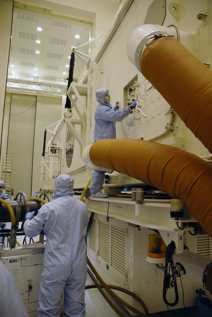 CAPE CANAVERAL, Fla. –  At NASA's Kennedy Space Center in Florida, workers in a clean room of the Payload Hazardous Servicing Facility, or PHSF, check the controls on the payload canister with the Hubble Space Telescope equipment inside. The payload comprises four carriers holding various equipment for the mission. The canister maintains a controlled environment.  In the PHSF, the carriers will be stored until a new target launch date can be set for Atlantis’ STS-125 mission in 2009. Atlantis’ October target launch date was delayed after a device on board Hubble used in the storage and transmission of science data to Earth shut down on Sept. 27. Replacing the broken device will be added to Atlantis’ servicing mission to the telescope. Photo credit: NASA/Troy Cryder