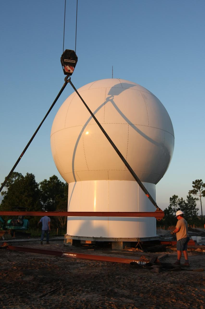CAPE CANAVERAL, Fla. - Workers prepare the radome to be lifted by a crane to the top of a new Doppler weather radar tower being built in an area near S.R. 520 in Orange County, Fla. The dome houses the weather radar dish and pedestal and protects them from the elements.  The new tower will replace one at nearby Patrick Air Force Base and will be used by NASA's Kennedy Space Center, the 45th Space Wing and their customers. The tower will be able to monitor weather conditions directly above the launch pads at Kennedy. The weather radar is essential in issuing lightning and other severe weather warnings and vital in evaluating lightning launch commit criteria. The new radar, replacing what was installed 25 years ago, includes Doppler capability to detect winds and identify the type, size and number of precipitation particles. The site is ideally distant from the launch pads and has unobstructed views of Cape Canaveral Air Force Station and Kennedy. Photo credit: NASA/Dimitri Gerondidakis