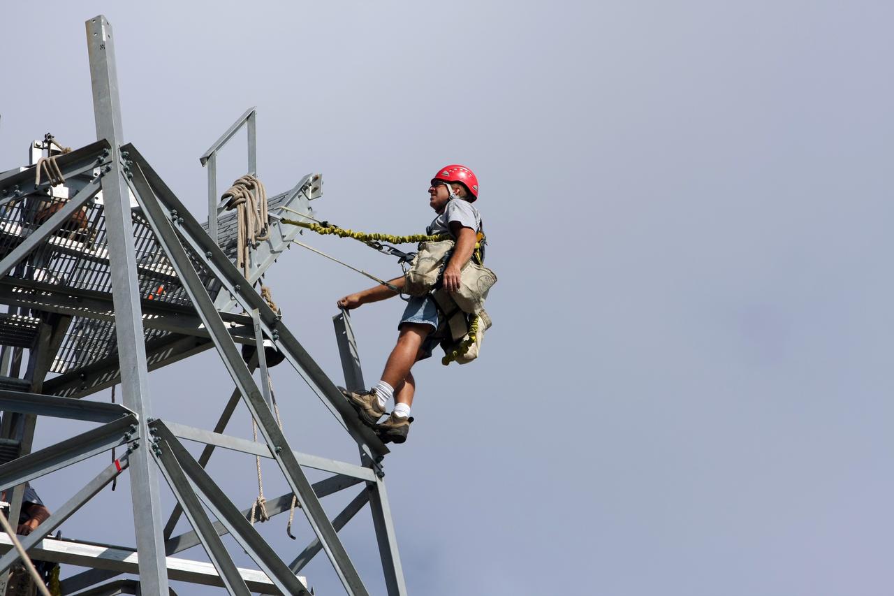 CAPE CANAVERAL, Fla. - A worker awaits the delivery by crane of the radome to the top of a new Doppler weather radar tower being built in an area near S.R. 520 in Orange County, Fla. The dome houses the weather radar dish and pedestal and protects them from the elements.  The new tower will replace one at nearby Patrick Air Force Base and will be used by NASA's Kennedy Space Center, the 45th Space Wing and their customers. The tower will be able to monitor weather conditions directly above the launch pads at Kennedy. The weather radar is essential in issuing lightning and other severe weather warnings and vital in evaluating lightning launch commit criteria. The new radar, replacing what was installed 25 years ago, includes Doppler capability to detect winds and identify the type, size and number of precipitation particles. The site is ideally distant from the launch pads and has unobstructed views of Cape Canaveral Air Force Station and Kennedy. Photo credit: NASA/Dimitri Gerondidakis