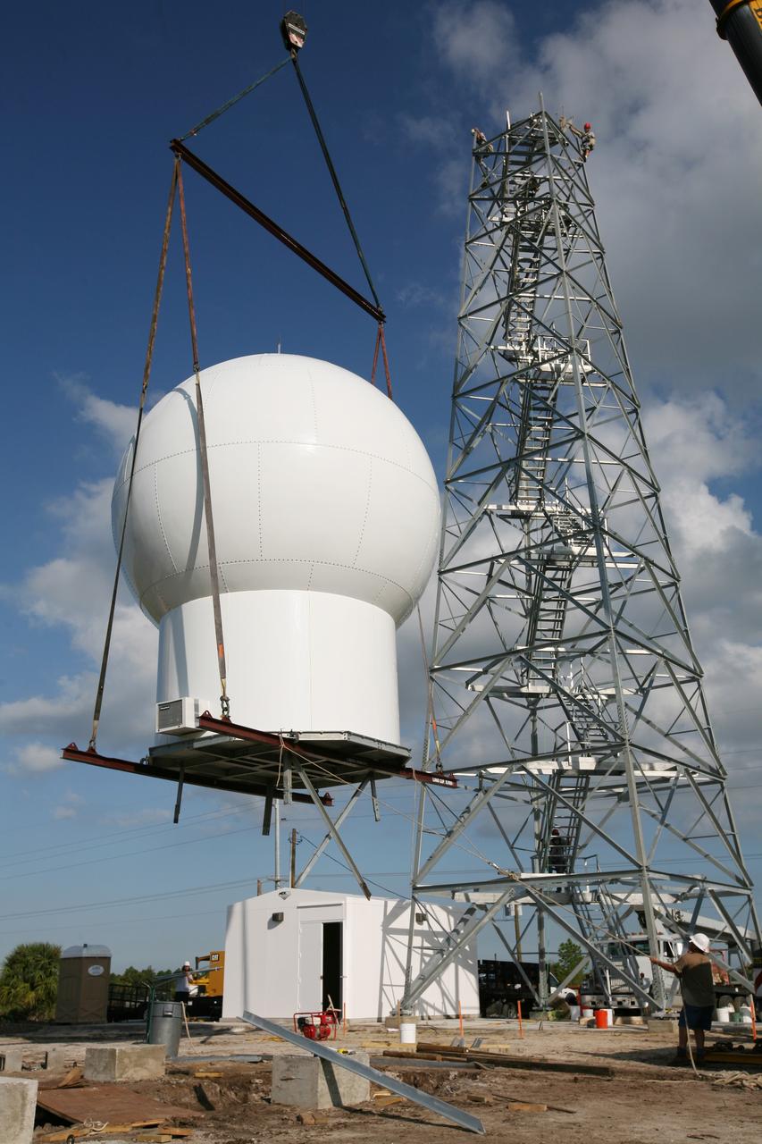 CAPE CANAVERAL, Fla. - A crane lifts the radome to the top of a new Doppler weather radar tower being built in an area near S.R. 520 in Orange County, Fla. The dome houses the weather radar dish and pedestal and protects them from the elements. The new tower will replace one at nearby Patrick Air Force Base and will be used by NASA's Kennedy Space Center, the 45th Space Wing and their customers. The tower will be able to monitor weather conditions directly above the launch pads at Kennedy. The weather radar is essential in issuing lightning and other severe weather warnings and vital in evaluating lightning launch commit criteria. The new radar, replacing what was installed 25 years ago, includes Doppler capability to detect winds and identify the type, size and number of precipitation particles. The site is ideally distant from the launch pads and has unobstructed views of Cape Canaveral Air Force Station and Kennedy. Photo credit: NASA/Dimitri Gerondidakis