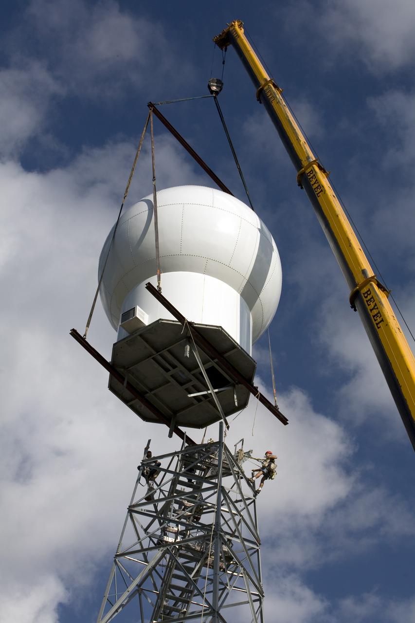 CAPE CANAVERAL, Fla. - A crane positions the radome on top of a new Doppler weather radar tower being built in an area near S.R. 520 in Orange County, Fla. The dome houses the weather radar dish and pedestal and protects them from the elements. The new tower will replace one at nearby Patrick Air Force Base and will be used by NASA's Kennedy Space Center, the 45th Space Wing and their customers. The tower will be able to monitor weather conditions directly above the launch pads at Kennedy. The weather radar is essential in issuing lightning and other severe weather warnings and vital in evaluating lightning launch commit criteria. The new radar, replacing what was installed 25 years ago, includes Doppler capability to detect winds and identify the type, size and number of precipitation particles. The site is ideally distant from the launch pads and has unobstructed views of Cape Canaveral Air Force Station and Kennedy. Photo credit: NASA/Dimitri Gerondidakis