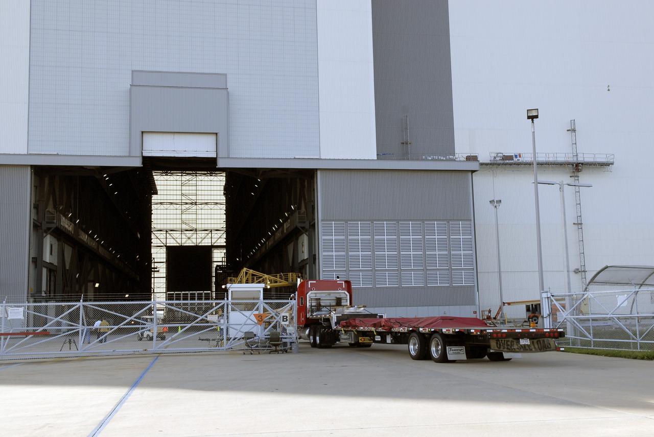 CAPE CANAVERAL, Fla. - One of five trucks transporting the Ares IX upper stage segments’ ballast assemblies arrives at the Vehicle Assembly Building at NASA’s Kennedy Space, part of the preparations for the test of the Ares IX rocket. These ballast assemblies will be installed in the upper stage 1 and 7 segments and will mimic the mass of the fuel.  Their total weight is approximately 160,000 pounds.  The test launch of the Ares IX in 2009 will be the first designed to determine the flight-worthiness of the Ares I rocket.  Ares I is an in-line, two-stage rocket that will transport the Orion crew exploration vehicle to low-Earth orbit. The Ares I first stage will be a five-segment solid rocket booster based on the four-segment design used for the space shuttle. Ares I’s fifth booster segment allows the launch vehicle to lift more weight and reach a higher altitude before the first stage separates from the upper stage, which ignites in midflight to propel the Orion spacecraft to Earth orbit.  Photo credit: NASA/Kim Shiflett