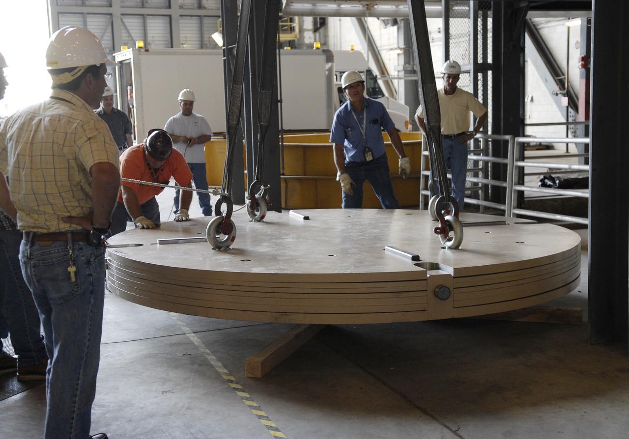 CAPE CANAVERAL, Fla. - Workers lower an Ares IX upper stage segments’ ballast assembly onto the floor of high bay 4 in the Vehicle Assembly Building at NASA’s Kennedy Space Center, part of the preparations for the test of the Ares IX rocket. These ballast assemblies will be installed in the upper stage 1 and 7 segments and will mimic the mass of the fuel.  Their total weight is approximately 160,000 pounds.  The test launch of the Ares IX in 2009 will be the first designed to determine the flight-worthiness of the Ares I rocket.  Ares I is an in-line, two-stage rocket that will transport the Orion crew exploration vehicle to low-Earth orbit. The Ares I first stage will be a five-segment solid rocket booster based on the four-segment design used for the space shuttle. Ares I’s fifth booster segment allows the launch vehicle to lift more weight and reach a higher altitude before the first stage separates from the upper stage, which ignites in midflight to propel the Orion spacecraft to Earth orbit.  Photo credit: NASA/Kim Shiflett