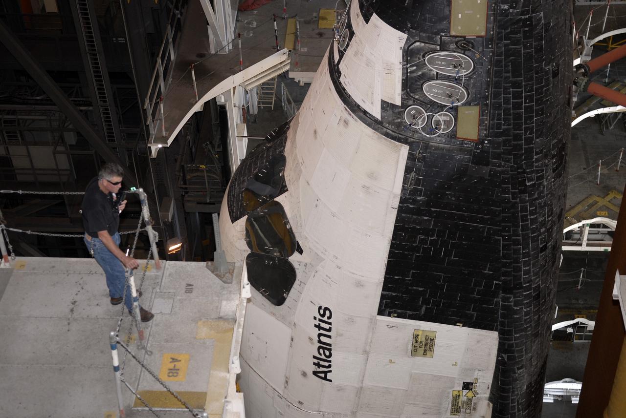 CAPE CANAVERAL, Fla. - In the Vehicle Assembly Building's high bay 3 at NASA's Kennedy Space Center in Florida, a worker closely observes space shuttle Atlantis as it rolls in after leaving Launch Pad 39A.  In the VAB, Atlantis will await launch on its STS-125 mission to repair NASA's Hubble Space Telescope.  First motion of Atlantis off the pad was at 6:48 a.m. EDT. Atlantis' targeted launch on Oct. 14 was delayed when a system that transfers science data from the orbiting observatory to Earth malfunctioned on Sept. 27. The new target launch date is under review.  Photo credit: NASA/Kim Shiflett