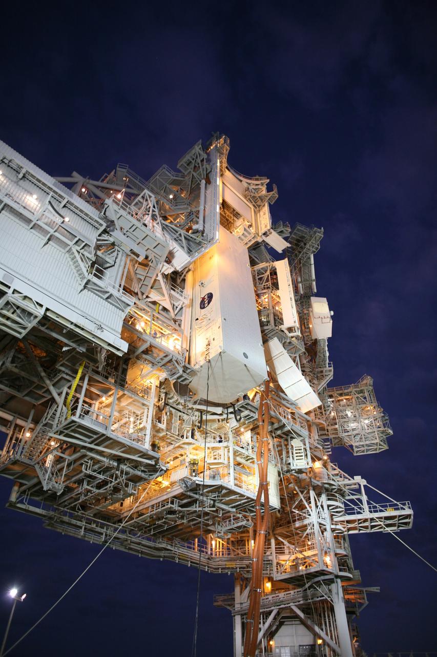 CAPE CANAVERAL, Fla. -    On Launch Pad 39A at NASA's Kennedy Space Center in Florida, the payload canister with space shuttle Endeavour's STS-126 mission payload inside is lifted to the Payload Changeout Room, or PCR, above. Inside the canister are the Multi-Purpose Logistics Module Leonardo and the Lightweight Multi-Purpose Experiment Support Structure Carrier. The red umbilical lines attached preserve the environmentally controlled interior. The payload canister will release its cargo into the PCR.  Later, the payload will be installed in Endeavour's payload bay.  Endeavour is targeted for launch on Nov. 14.  Photo credit: NASA/Dimitri Gerondidakis