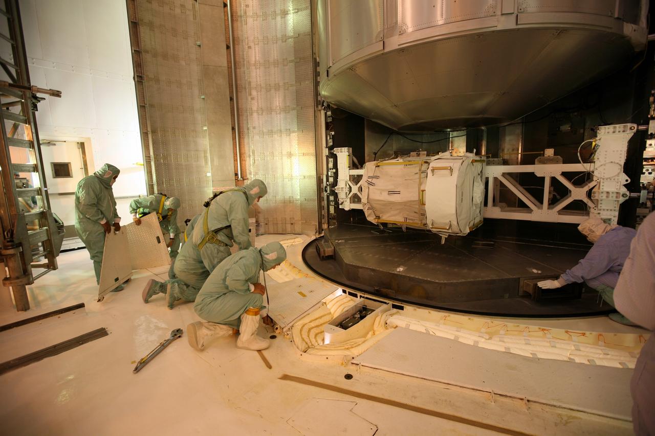 CAPE CANAVERAL, Fla. - On Launch Pad 39A at NASA's Kennedy Space Center in Florida, workers in the Payload Changeout Room prepare for the removal of the Multi-Purpose Logistics Module Leonardo (center) and the Lightweight Multi-Purpose Experiment Support Structure Carrier (bottom) from the payload canister. Later, the payload will be installed in Endeavour's payload bay. Endeavour is targeted for launch on Nov. 14. Photo credit: NASA/Dimitri Gerondidakis