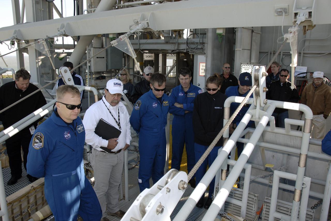 CAPE CANAVERAL, Fla. – At the 195-foot level of the fixed service structure on Launch Pad 39A at NASA's Kennedy Space Center in Florida, STS-126 crew members look at the slidewire basket used for emergency exit from the pad.  Seen from left are Pilot Eric Boe, a safety instructor, Commander Chris Ferguson, and Mission Specialists Steve Bowen, Sandra Magnus and Donald Pettit.   The crew is at Kennedy to take part in the Terminal Countdown Demonstration Test, which includes equipment familiarization, emergency exit training and a simulated launch countdown.  On the STS-126 mission, space shuttle Endeavour's crew will deliver equipment and supplies to the International Space Station in preparation for expansion from a three- to six-person resident crew aboard the complex. The mission also will include four spacewalks to service the station’s Solar Alpha Rotary Joints. Endeavour is targeted to launch Nov. 14. Photo credit: NASA/Kim Shiflett