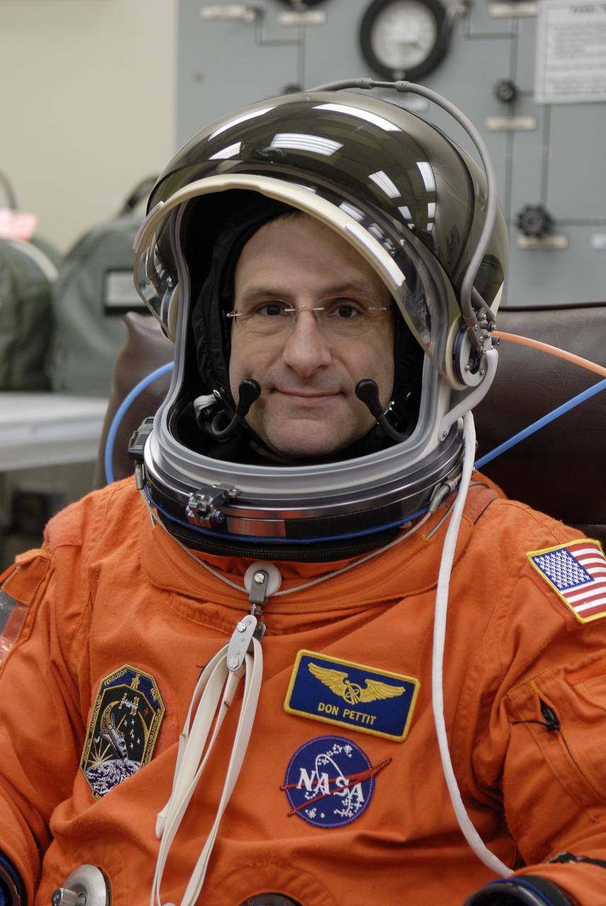 CAPE CANAVERAL, Fla. – STS-126 Mission Specialist Donald Pettit makes sure his helmet fits securely during suit-up in the Operations and Checkout Building at NASA's Kennedy Space Center in Florida. Pettit and other crew members are having their launch-and-entry suits fit-checked prior to heading for Launch Pad 39A. The crew will take part in a simulated launch countdown at the pad. The crew is at Kennedy to take part in the Terminal Countdown Demonstration Test, which includes equipment familiarization, emergency exit training and the simulated countdown. On the STS-126 mission, space shuttle Endeavour's crew will deliver equipment and supplies to the International Space Station in preparation for expansion from a three- to six-person resident crew aboard the complex. The mission also will include four spacewalks to service the station’s Solar Alpha Rotary Joints. Endeavour is targeted to launch Nov. 14. Photo credit: NASA/Kim Shiflett
