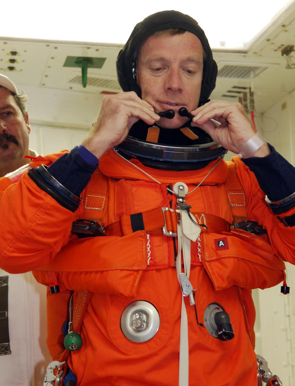 CAPE CANAVERAL, Fla. – In the White Room on Launch Pad 39A at NASA's Kennedy Space Center in Florida, STS-126 Commander Chris Ferguson adjusts his headset before donning his helmet. He will enter space shuttle Endeavour to take part in a simulated launch countdown with the other crew members. The crew is at Kennedy to take part in the Terminal Countdown Demonstration Test, which includes equipment familiarization, emergency exit training and the simulated countdown. On the STS-126 mission, space shuttle Endeavour's crew will deliver equipment and supplies to the International Space Station in preparation for expansion from a three- to six-person resident crew aboard the complex. The mission also will include four spacewalks to service the station’s Solar Alpha Rotary Joints. Endeavour is targeted to launch Nov. 14. Photo credit: NASA/Troy Cryder