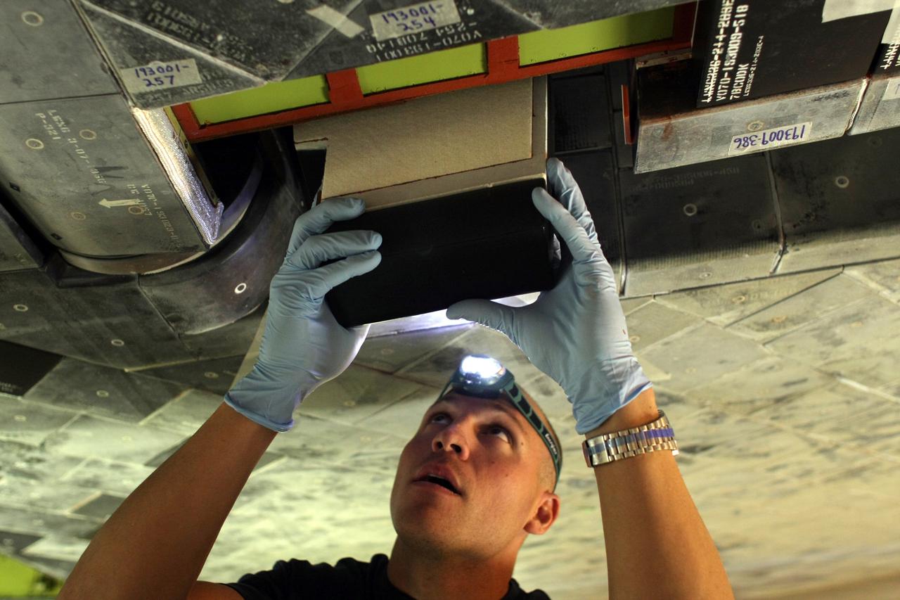 CAPE CANAVERAL, Fla. – United Space Alliance technicians remove and replace all the hub tiles on space shuttle Discovery before its STS-119 mission targeted for Feb. 12. Hub tiles, heat protection tiles, are difficult to install because of their location on the inboard side of the inboard elevons. On the STS-119 mission, Discovery will carry the S6 truss segment to complete the 361-foot-long backbone of the International Space Station. The truss includes the fourth pair of solar array wings and electronics that convert sunlight to power for the orbiting laboratory. Photo credit: NASA/Dimitri Gerondidakis