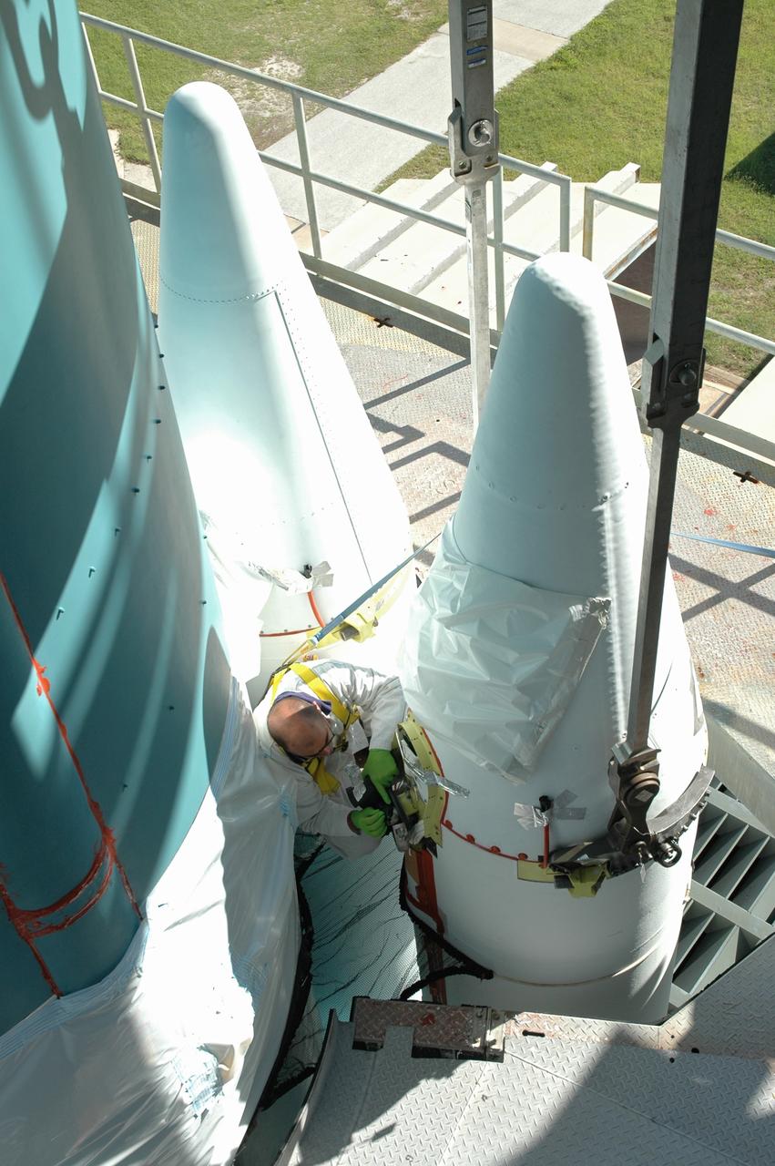 CAPE CANAVERAL, Fla. – On Launch Pad 17-B at Cape Canaveral Air Force Station in Florida, a worker makes adjustments on one of the solid rocket boosters being mated to the first stage of the Delta 2 launch vehicle that will carry the Kepler spacecraft into orbit. The Kepler mission is specifically designed to survey our region of the Milky Way galaxy to discover hundreds of Earth-size and smaller planets in or near the habitable zone and determine how many of the billions of stars in our galaxy have such planets. Results from this mission will allow us to place our solar system within the continuum of planetary systems in the Galaxy. NASA's planet-hunting Kepler mission is scheduled to launch no earlier than March 5, 2009. Photo credit: NASA/Jim Grossmann
